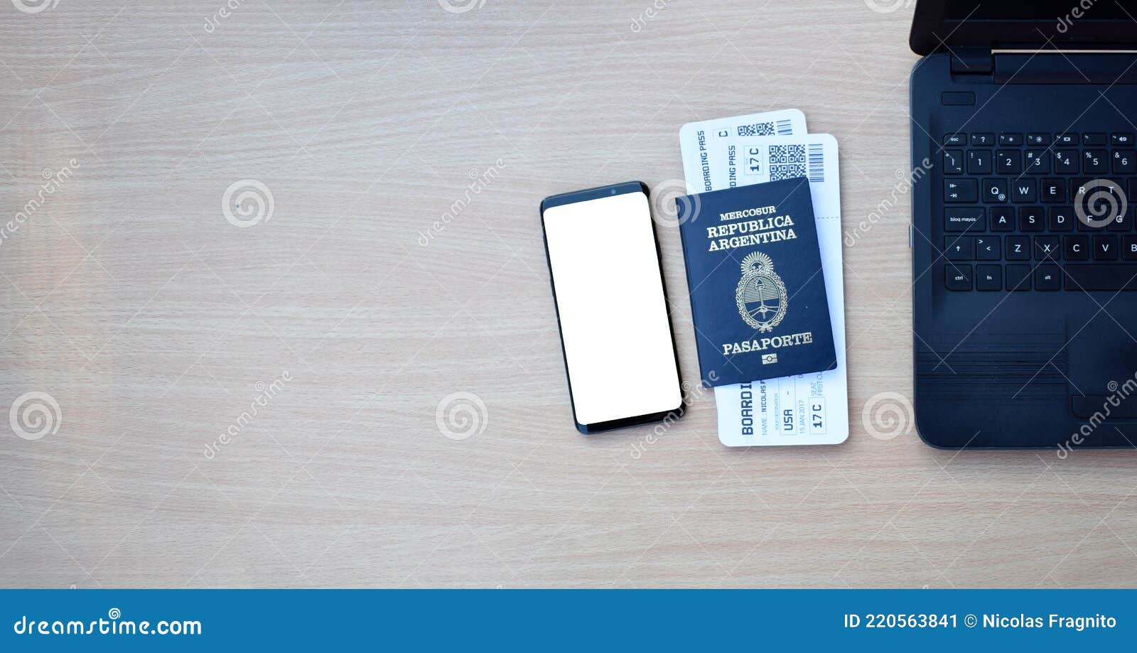 argentine passport and boarding pass with smartphone with copy space on wooden table