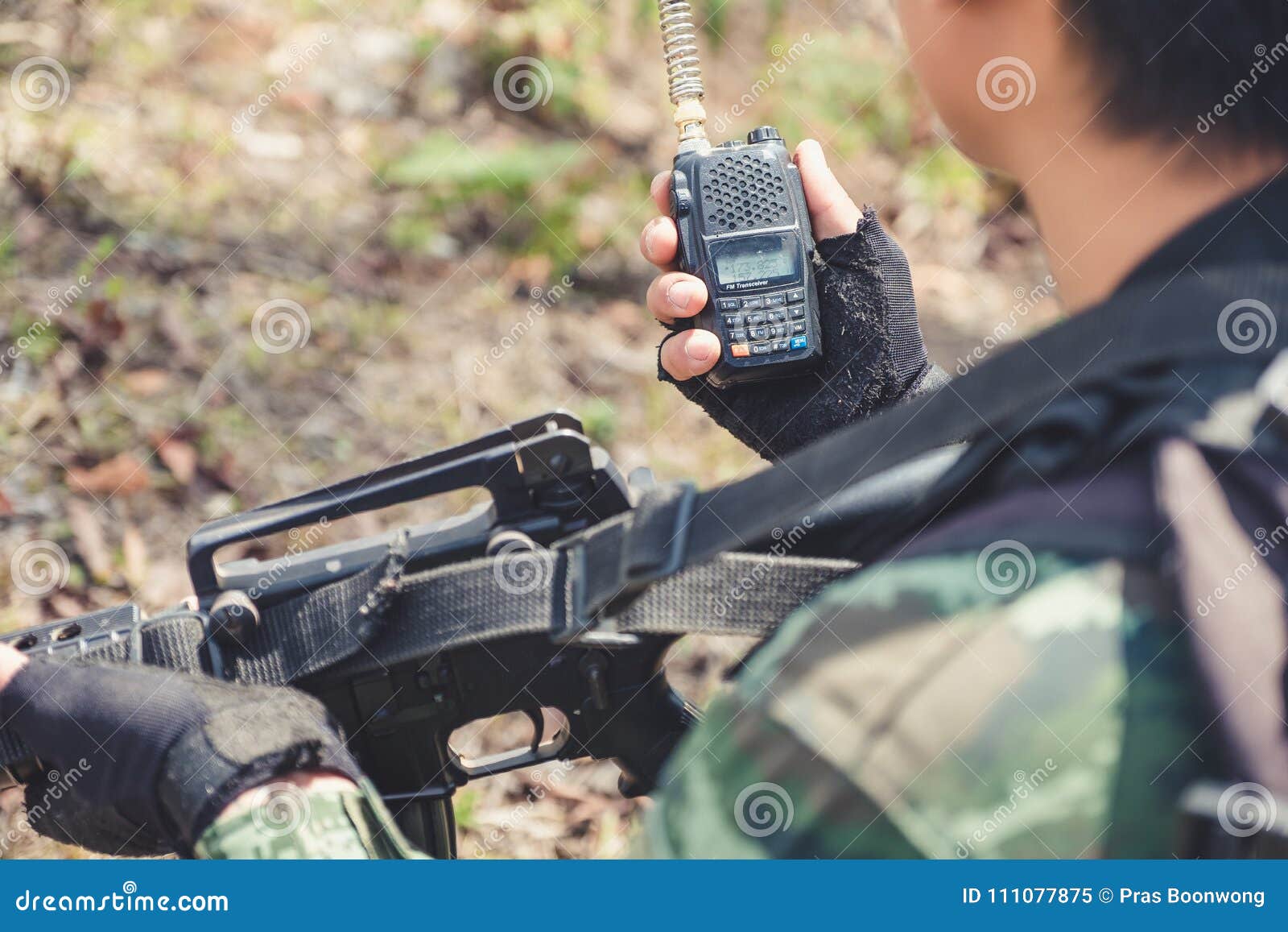An Armed Soldier Holding and Using Radio Communication in the Battle