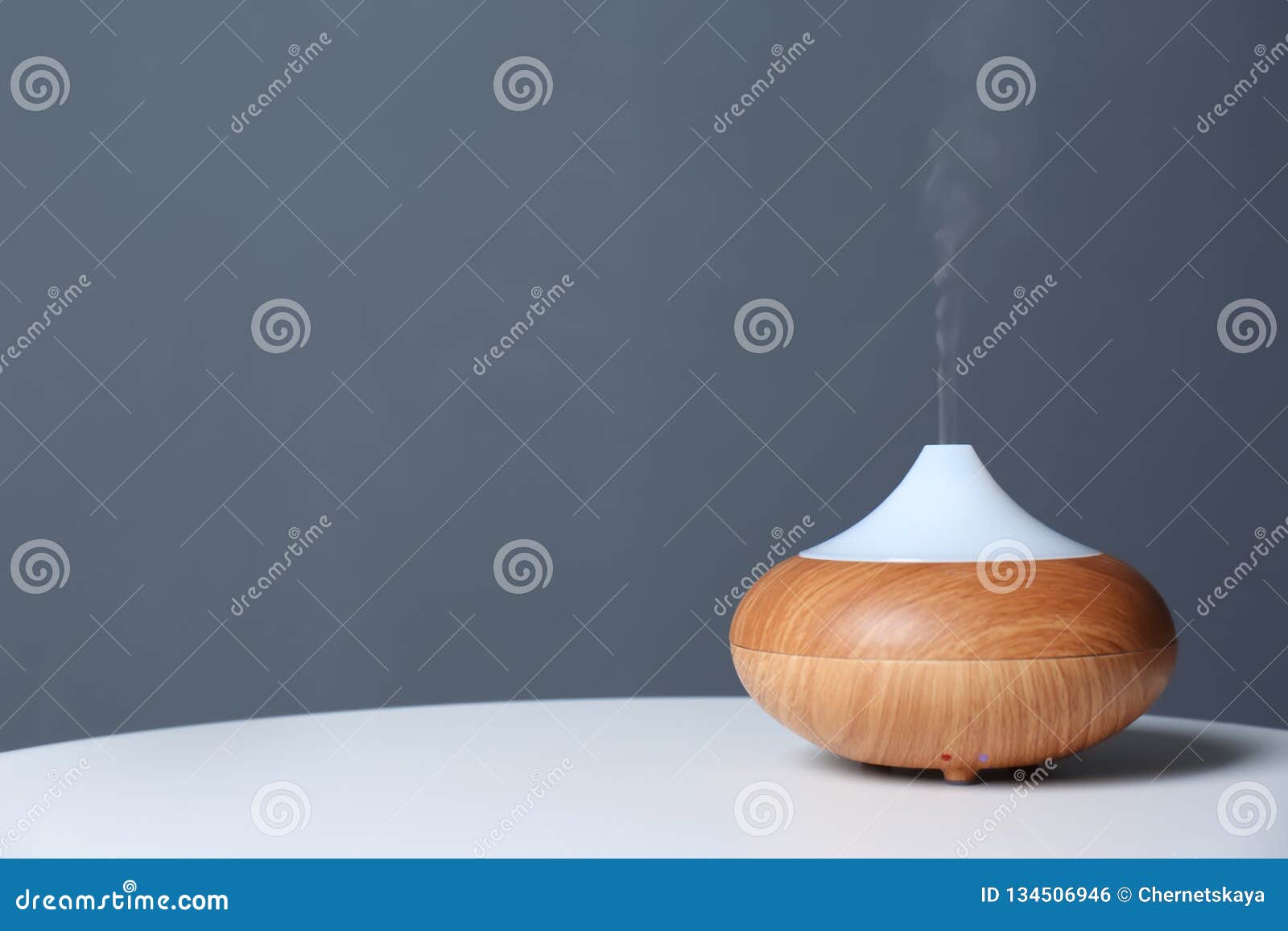 Aroma Oil Diffuser Lamp on Table Against Gray Background Stock Photo
