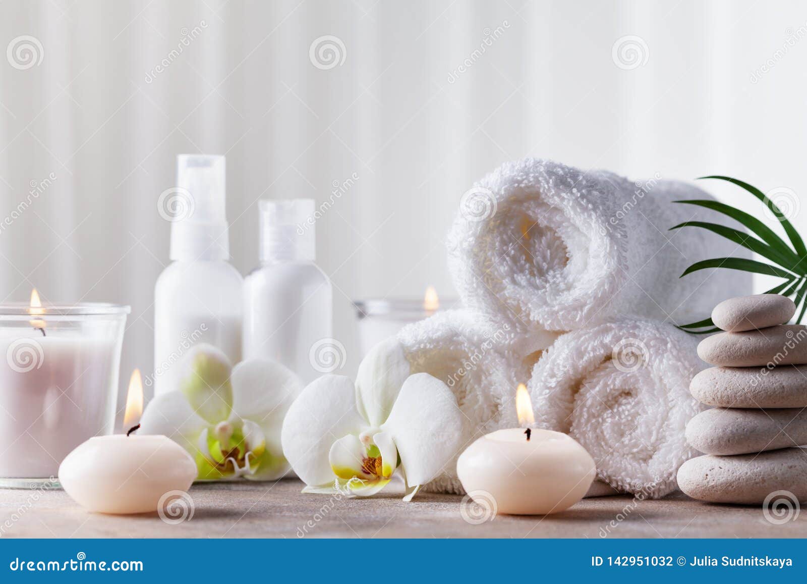 aromatherapy, spa, beauty treatment and wellness background with massage pebbles, orchid flowers, towels, cosmetic products