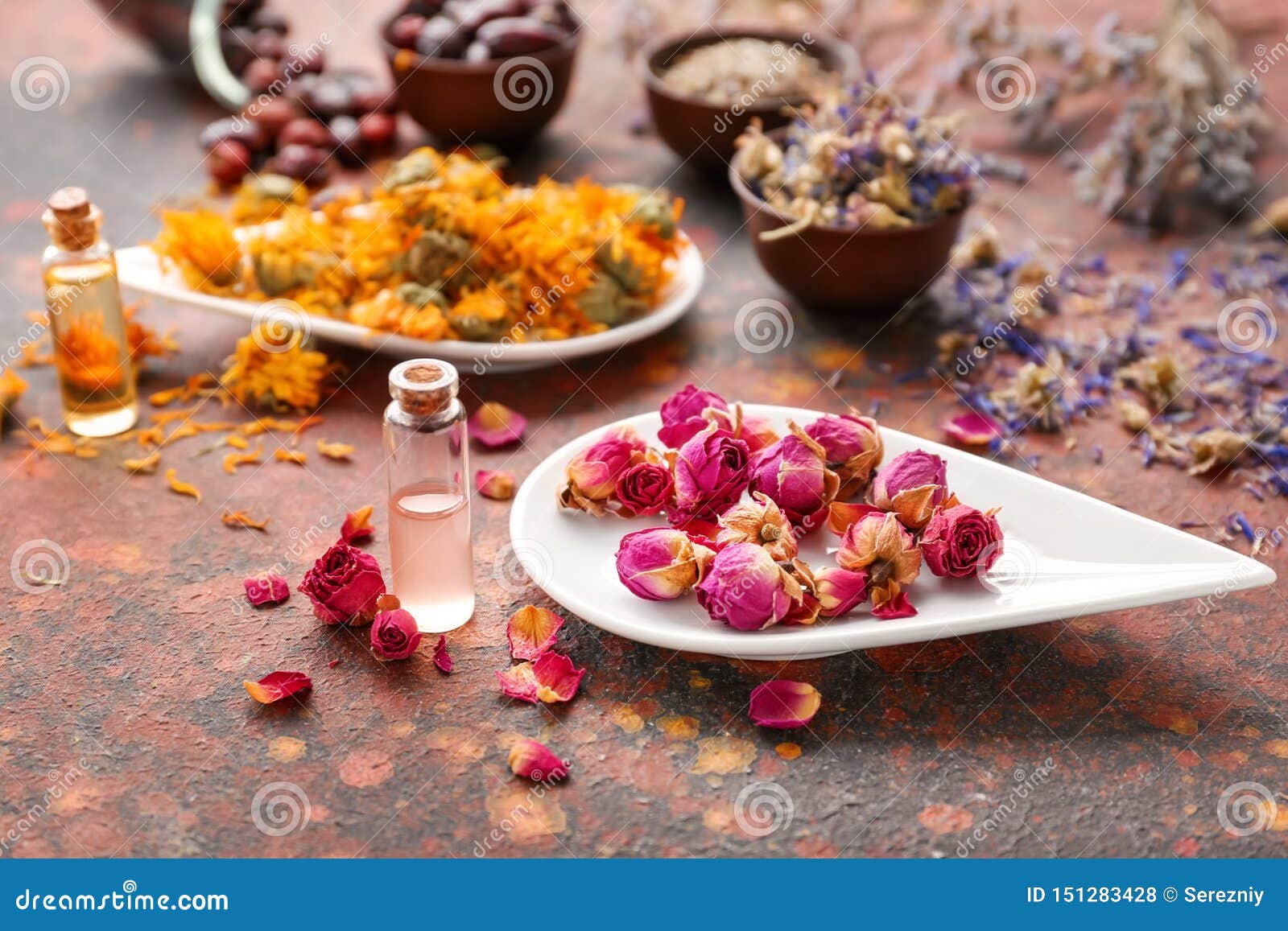Aromatic Dried Flowers with Essential Oil on Color Table Stock Photo