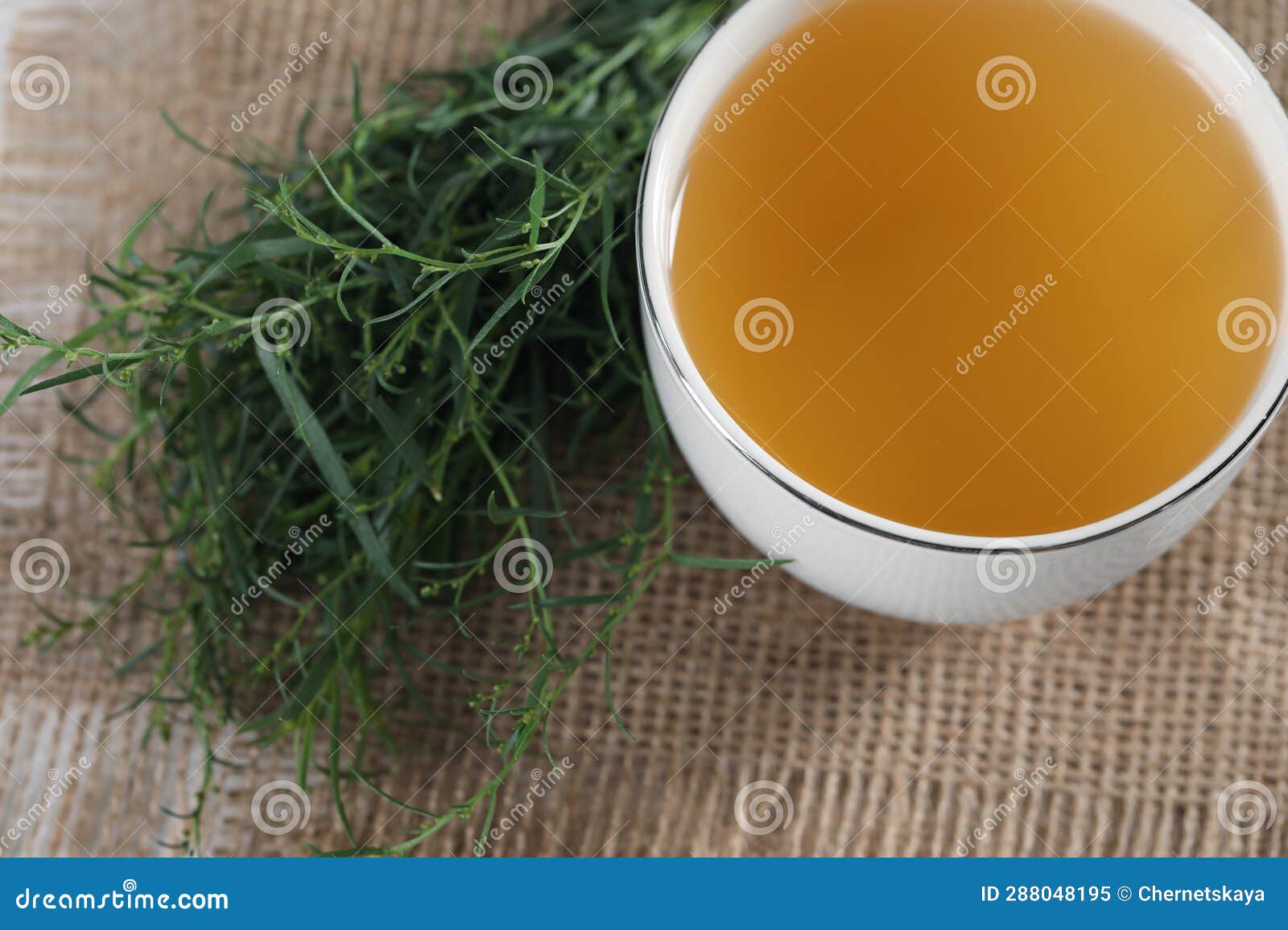 Aromatic Herbal Tea and Fresh Tarragon Sprigs on Table, Above View