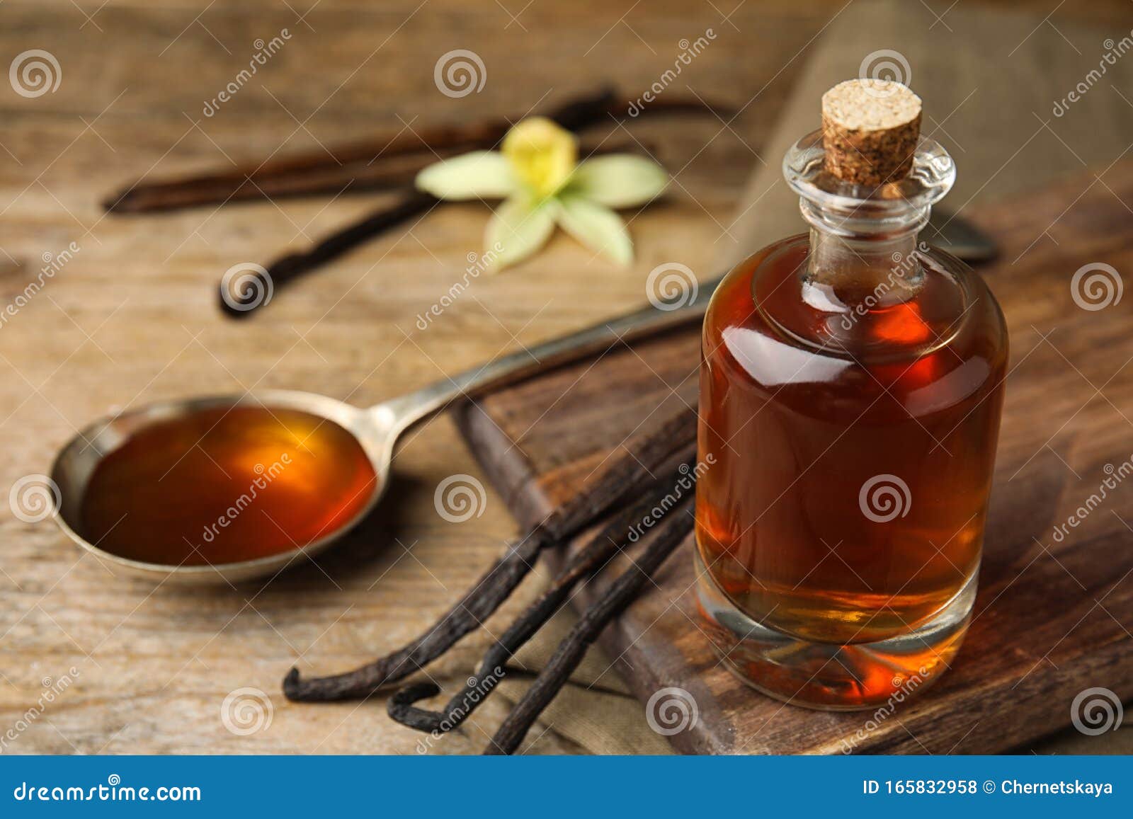 aromatic homemade vanilla extract on wooden table. space for text