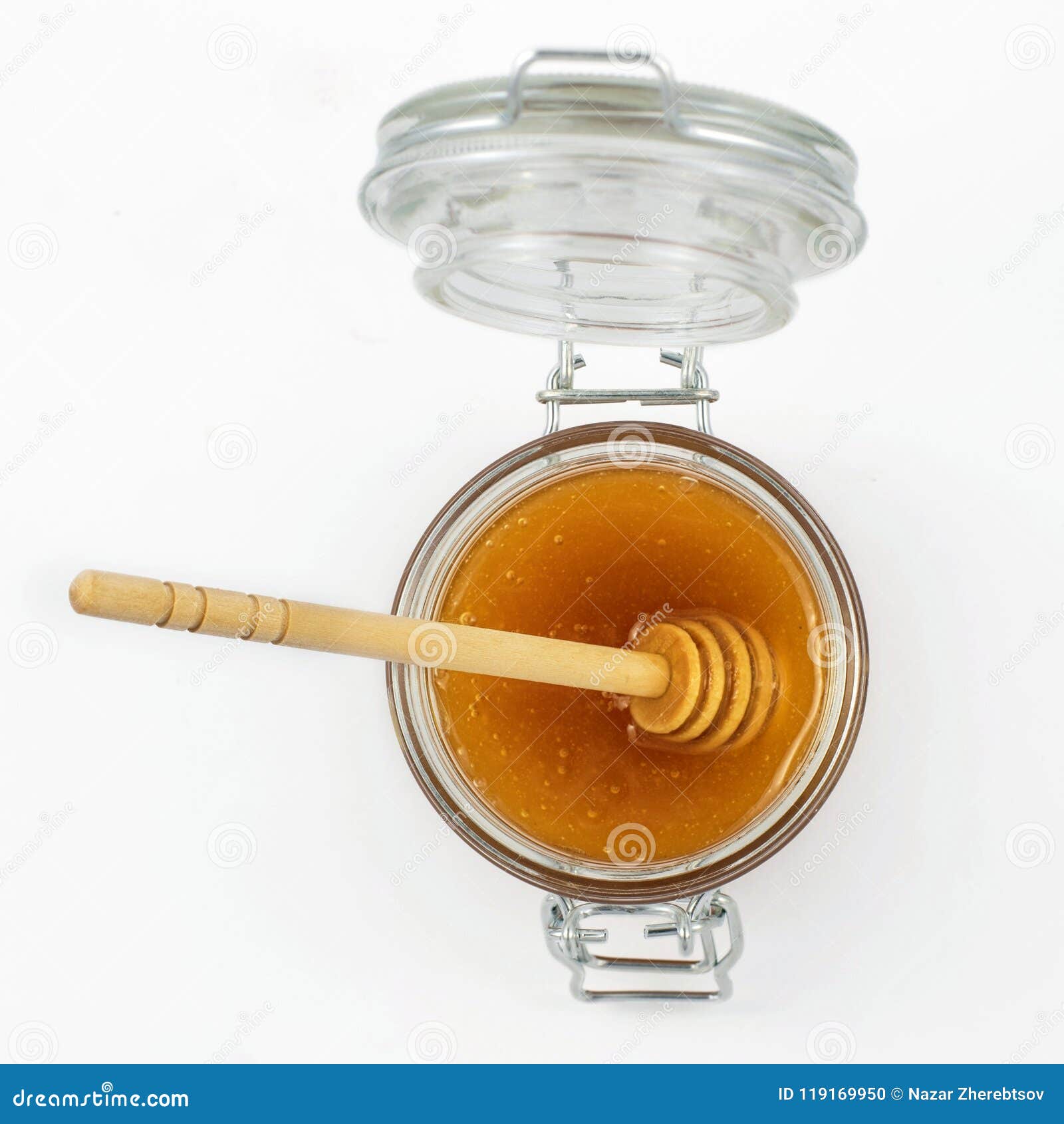 Aromatic Honey with Dipper into Jar Isolated on White Background. Top