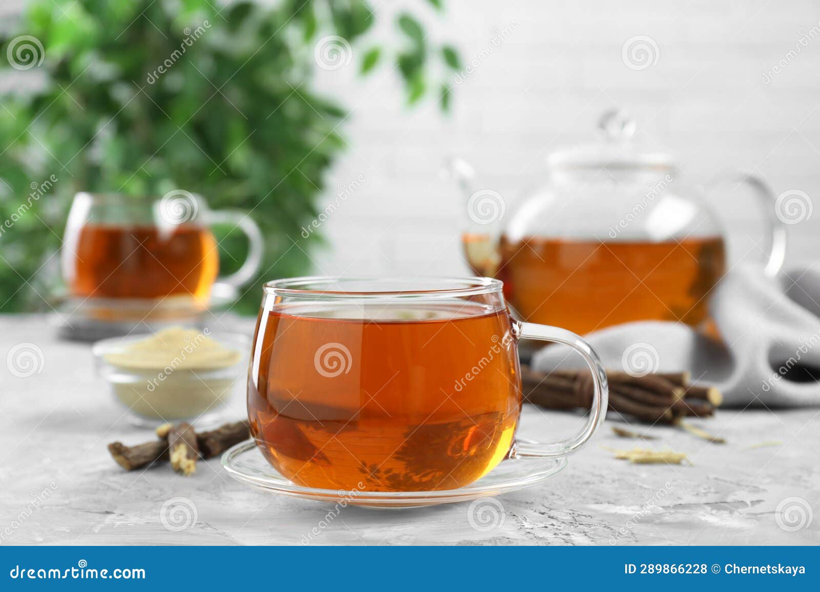 Aromatic Licorice Tea and Dried Sticks of Licorice Root on Light Gray