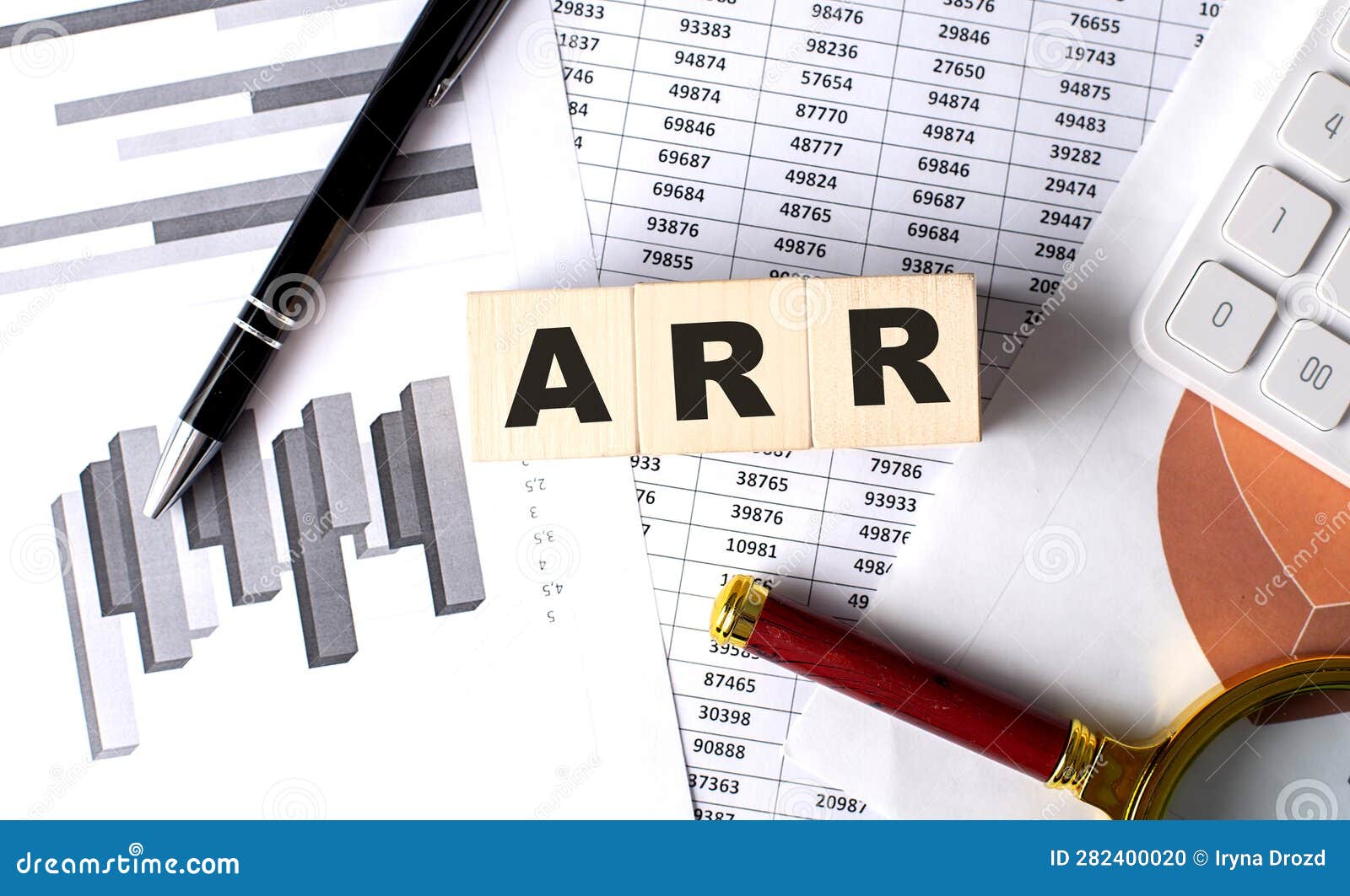 arr text on wooden block on graph background with pen and magnifier