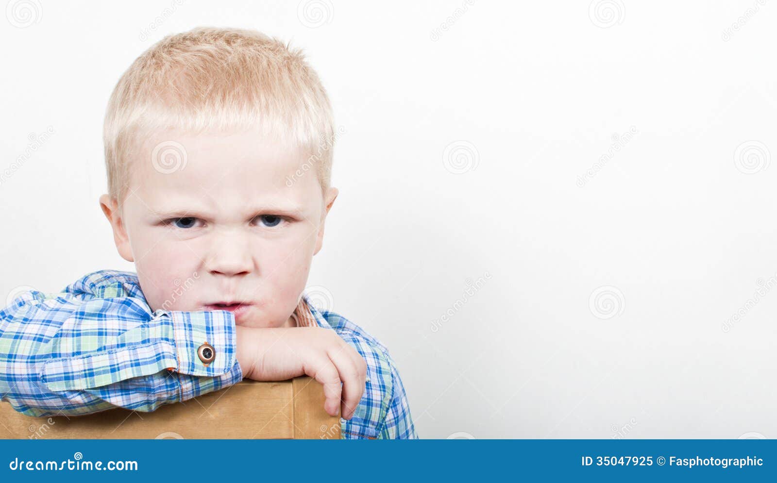 Bambino arrabbiato contro un fondo leggero grigio