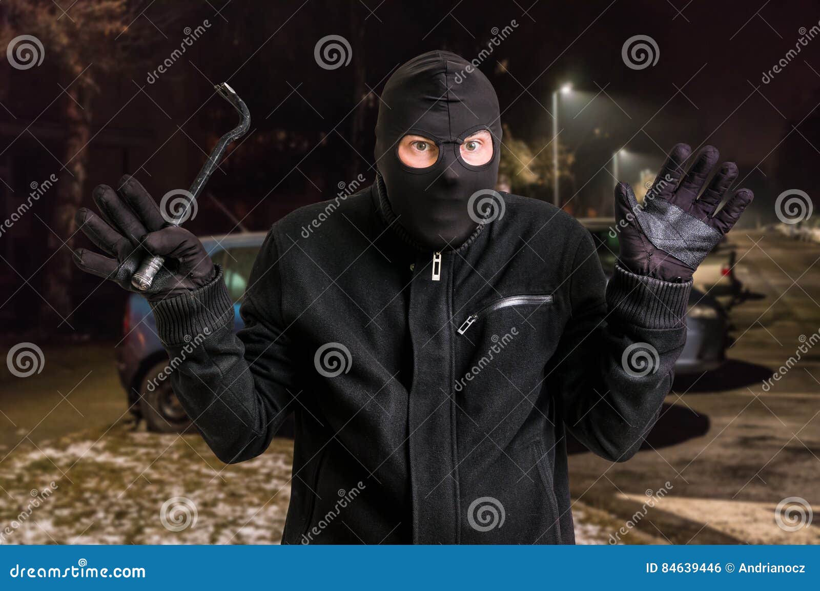 Arrested Masked Thief in Balaclava with Crowbar and Raised Arms Stock