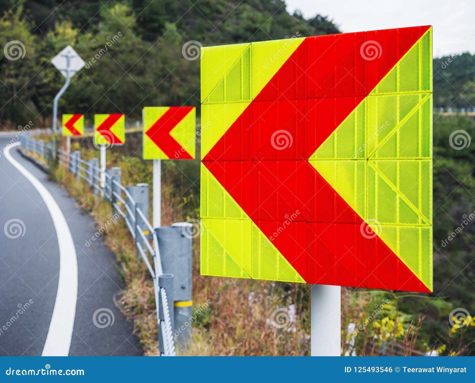 Road With Reflective Warning Pole Next To Shrubs Royalty Free Stock road-with-reflective-warning-pole-next-to-shrubs-royalty-free-stock