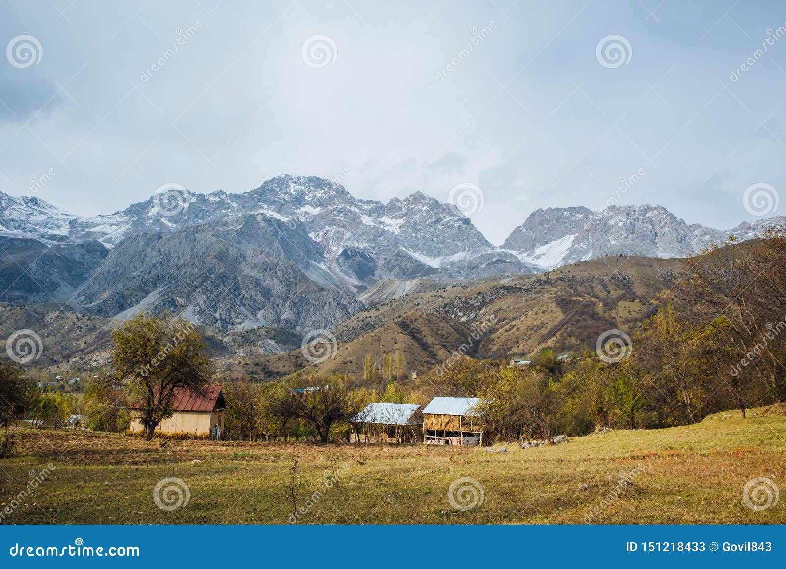 ARSLANBOB KIRGIZISTAN: Sikt av den Arslanbob byn i sydlig Kirgizistan, med berg i bakgrunden under höst. Sikt av den Arslanbob byn i sydlig Kirgizistan, med berg i bakgrunden under höst