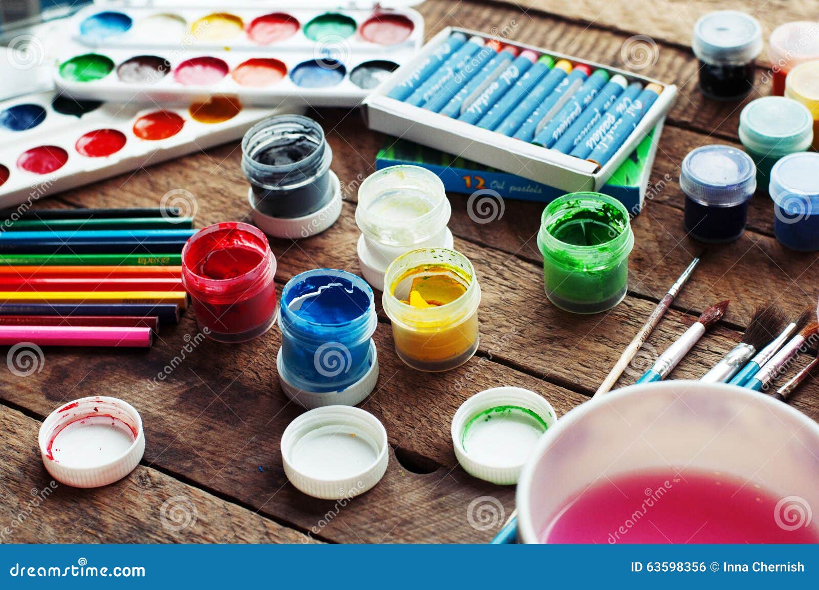 art of painting. paint buckets on wood background. different paint colors painting on wooden background. painting set: brushes, pa