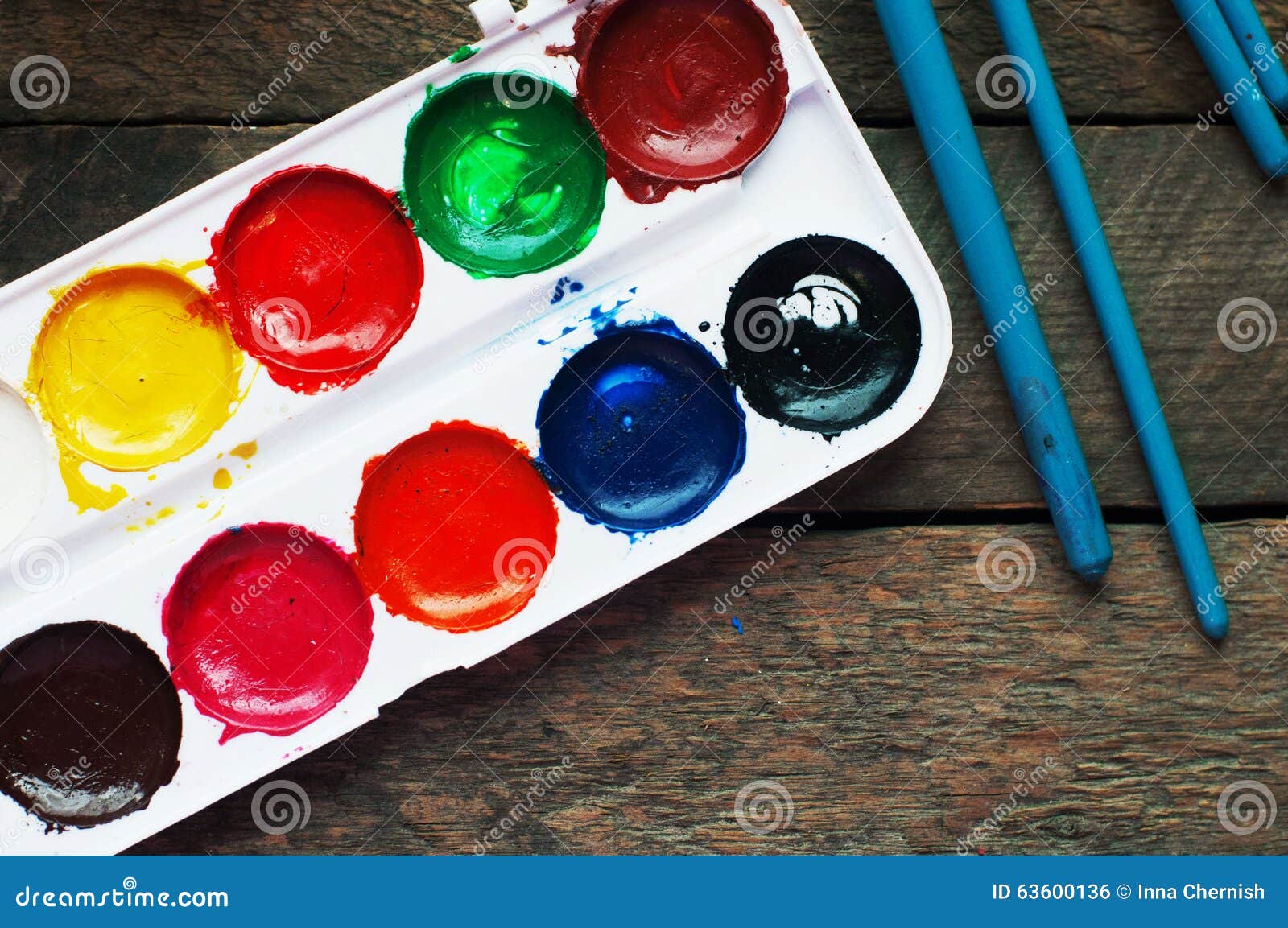 art of painting. paint buckets on wood background. different paint colors painting on wooden background. painting set: brushes, pa