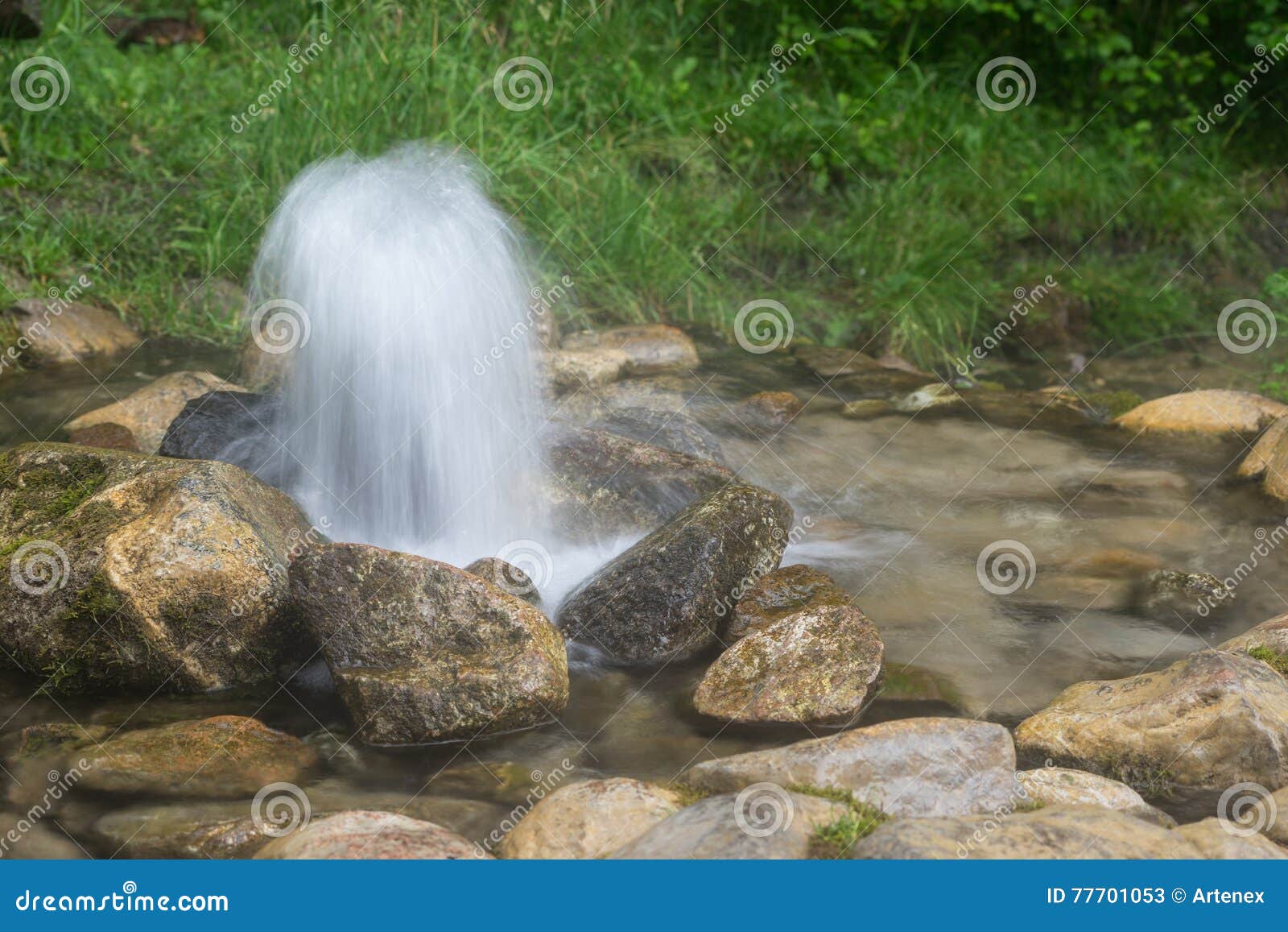 artesian well. eruption of spring, natural environment. stones and water. clean drinking groundwater erupting out of the ground.