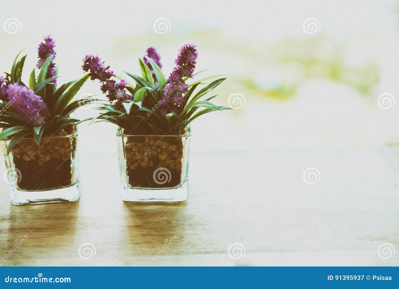 Artificial Flower In Small Glass Pot On A Wooden Table Stock
