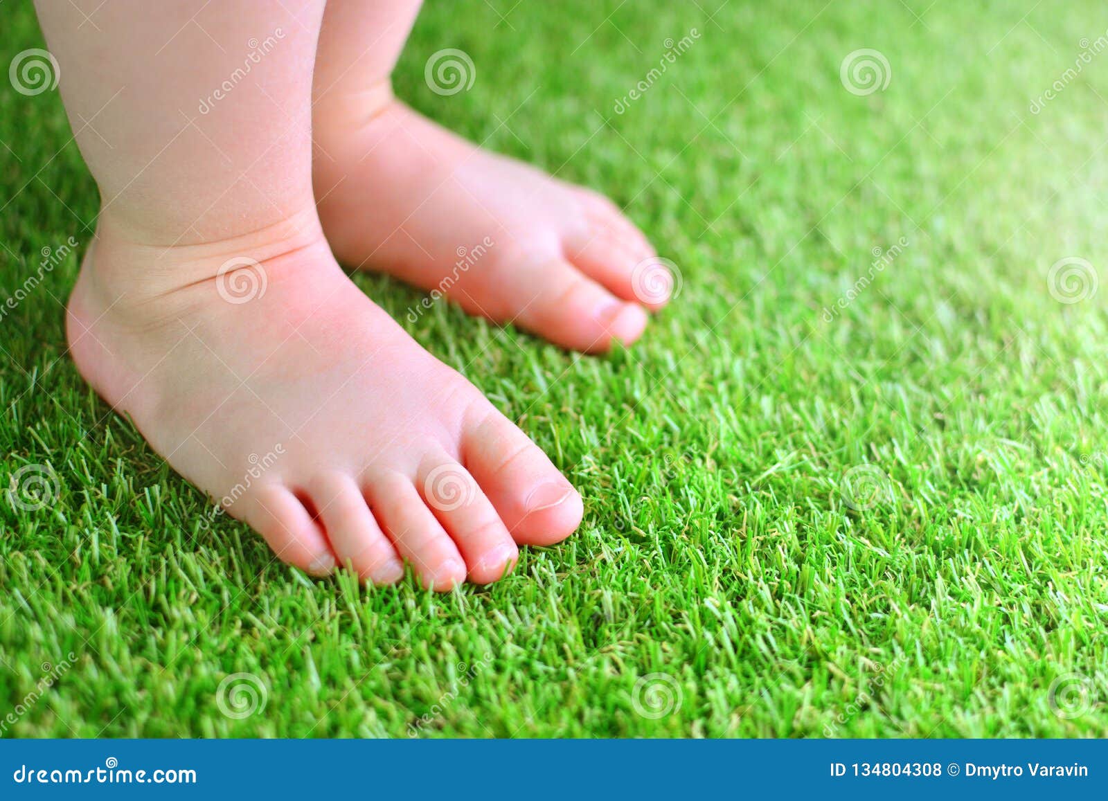 artificial grass background. tender foots of a baby on a green artificial turf.