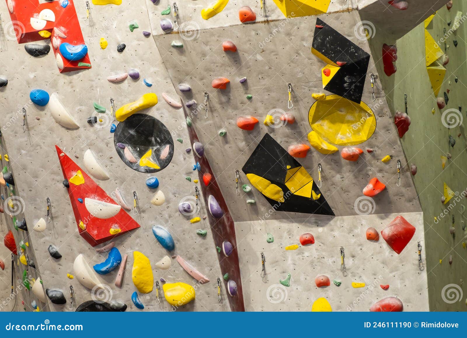 Artificial Rock Climbing Wall with Various Colored Grips Stock Photo