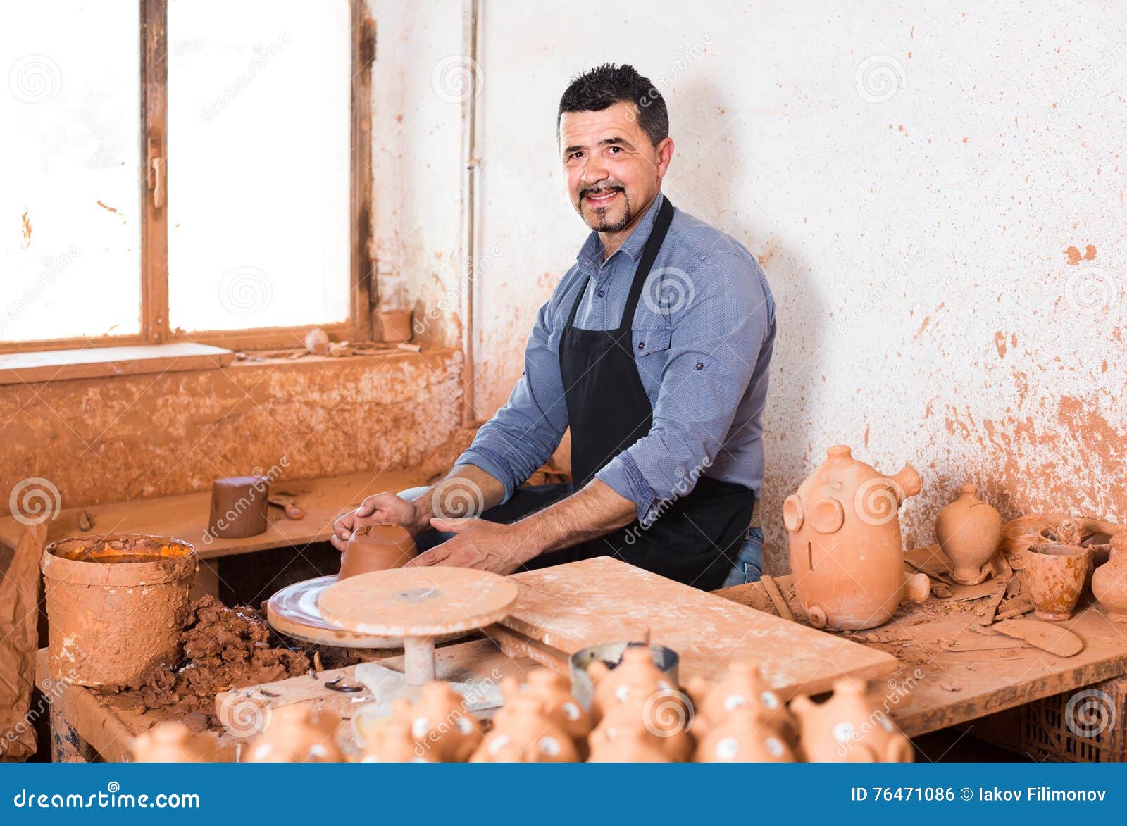 Artisan Man Creating Ceramic Piece on Spinning Pottery Wheel in Stock