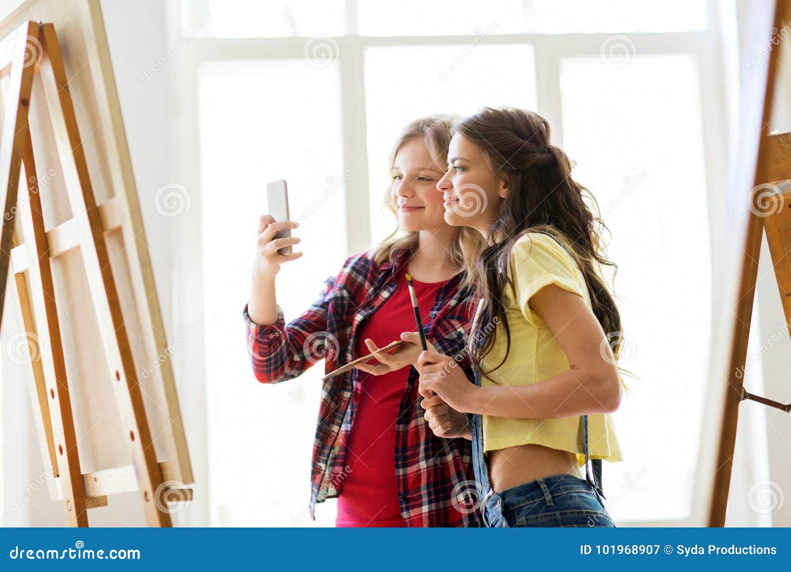 woman artist with easel painting at art studio Stock Photo by dolgachov