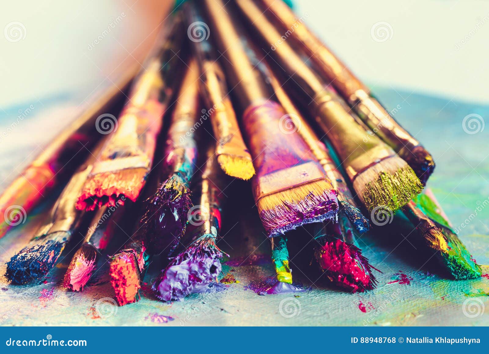 artist paintbrushes with paint closeup on artistic canvas.