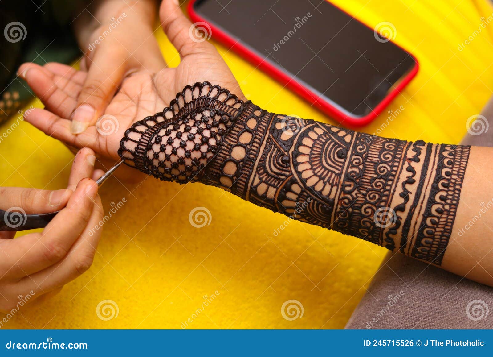An Artist Performing Mehandi or Henna Design on Female Hand Stock Photo