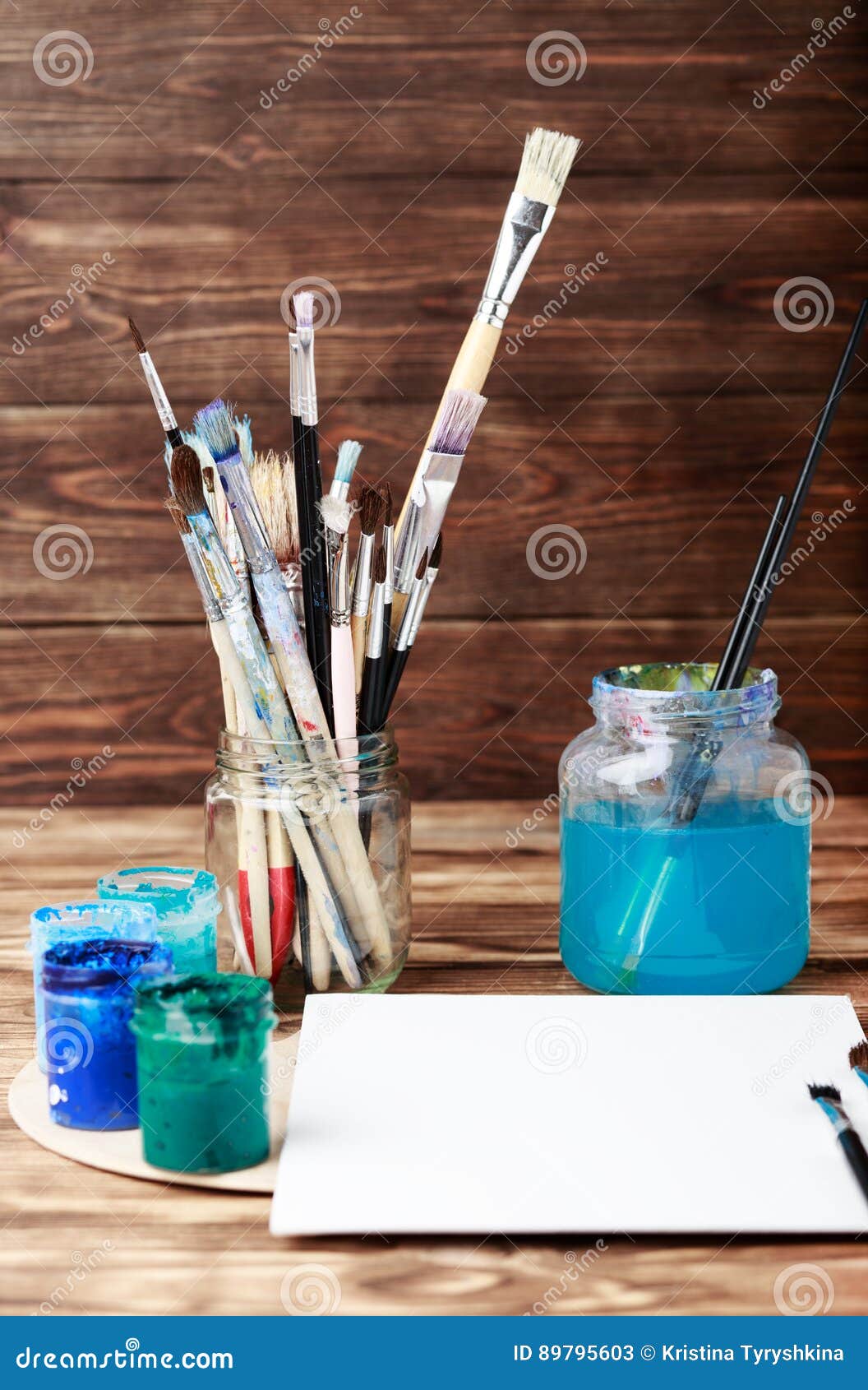 artist`s workshop. top view of paintbrushes palette and acrylic paints with white canvas. set of brushes and oil paints. art pictu
