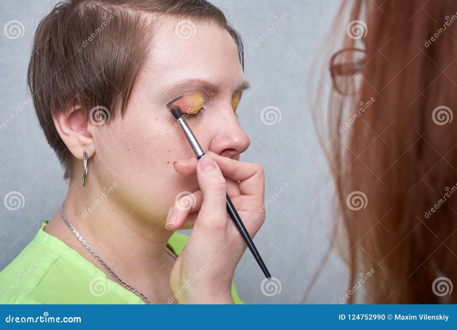 Artista Profesional Del Rostro Que Aplica Maquillaje Del Color En Cara Del  ` S De La Mujer En Fondo Gris Foto de archivo - Imagen de fondo, hembra:  124752990