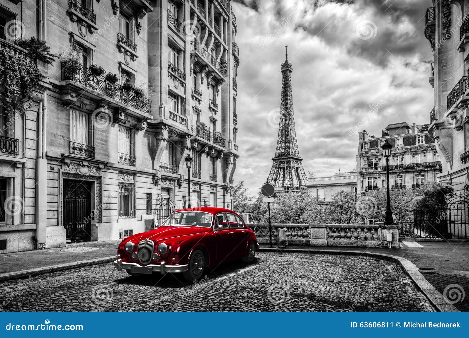 artistic paris, france. eiffel tower seen from the street with red retro limousine car.