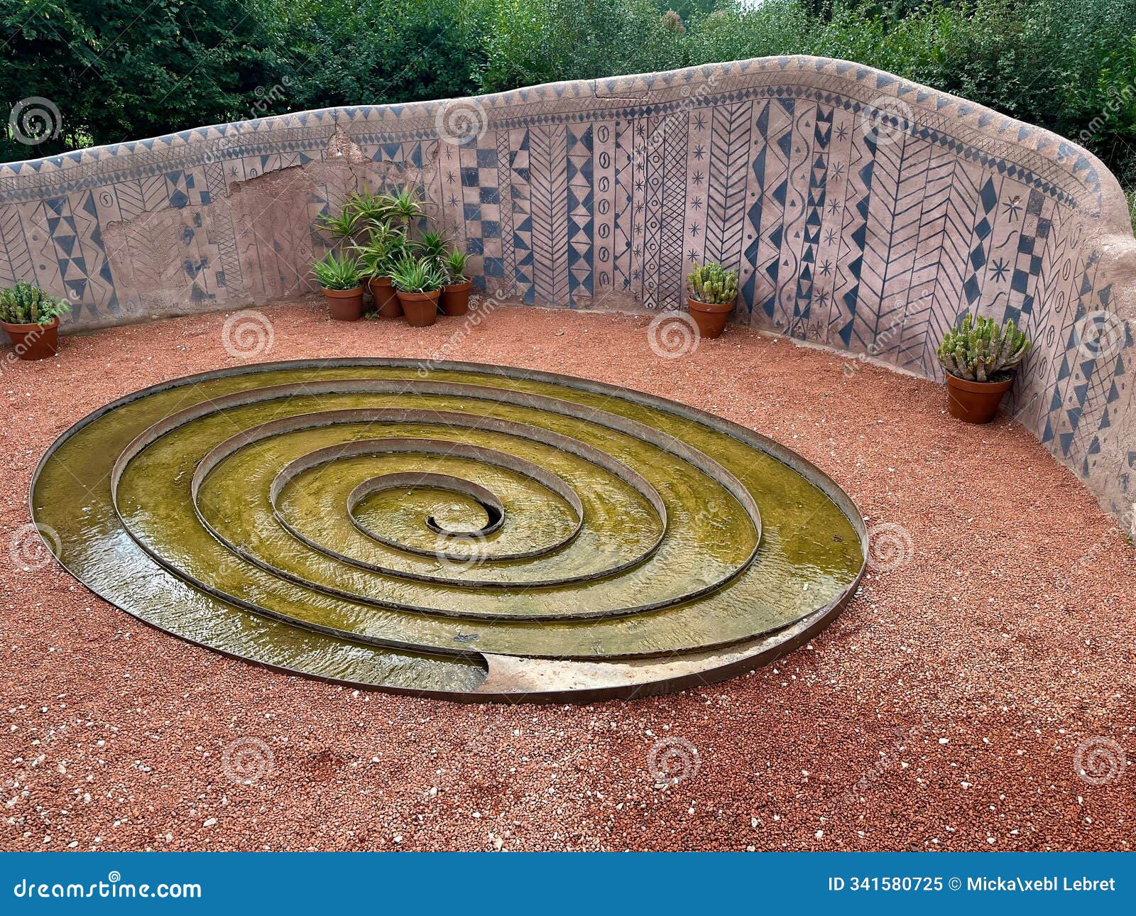 artistic spiral water feature in the gardens of domaine de chaumont-sur-loire surrounded by textured mosaic wall and succulent