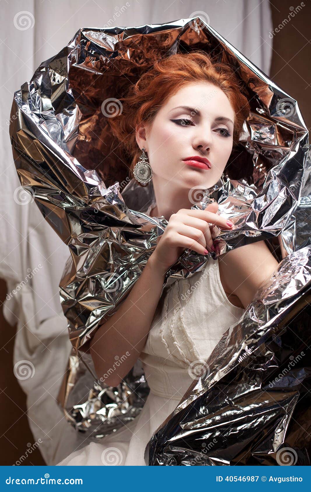 arty portrait of a fashionable queen-like model with silver foil