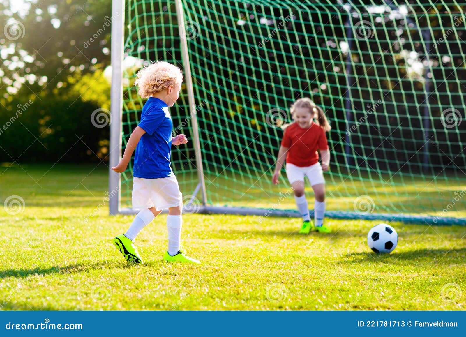 As crianças jogam futebol no campo ao ar livre. as crianças marcam um gol  no jogo