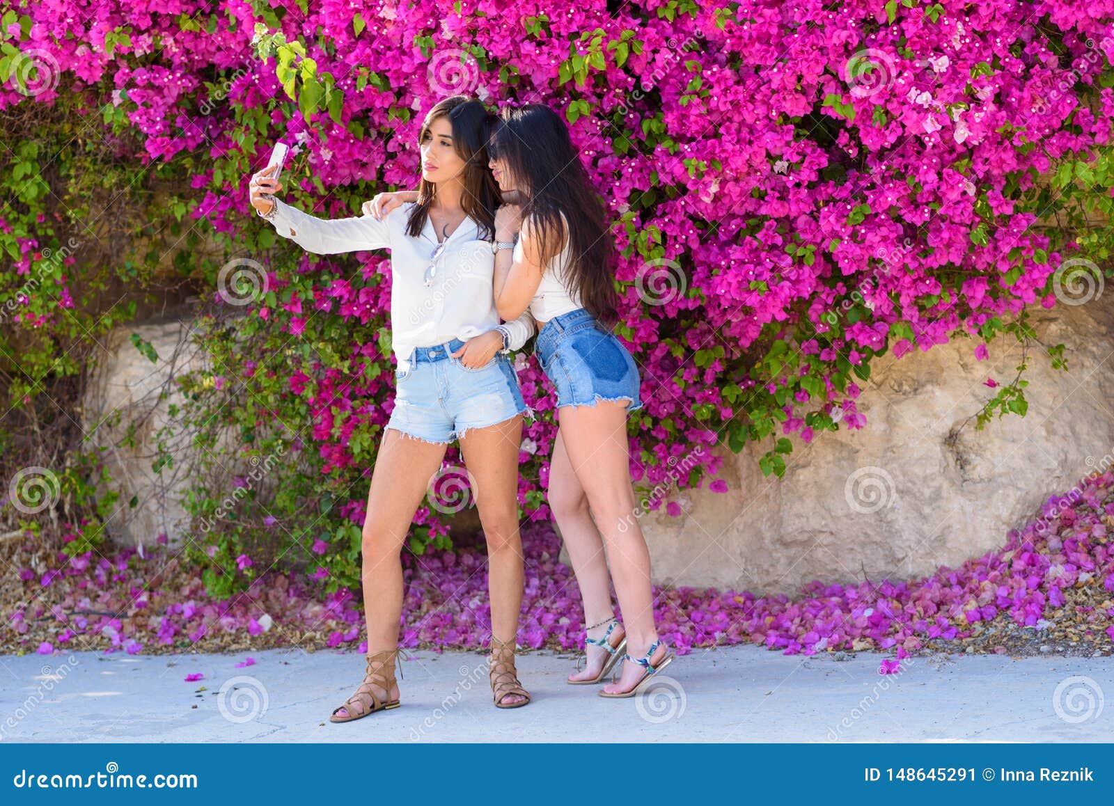 As Jovens Mulheres Felizes Bonitas Fazem O Selfie No Fundo Natural Colorido  De Flores Cor-de-rosa Brilhantes Imagem de Stock - Imagem de flor, beleza:  148645291