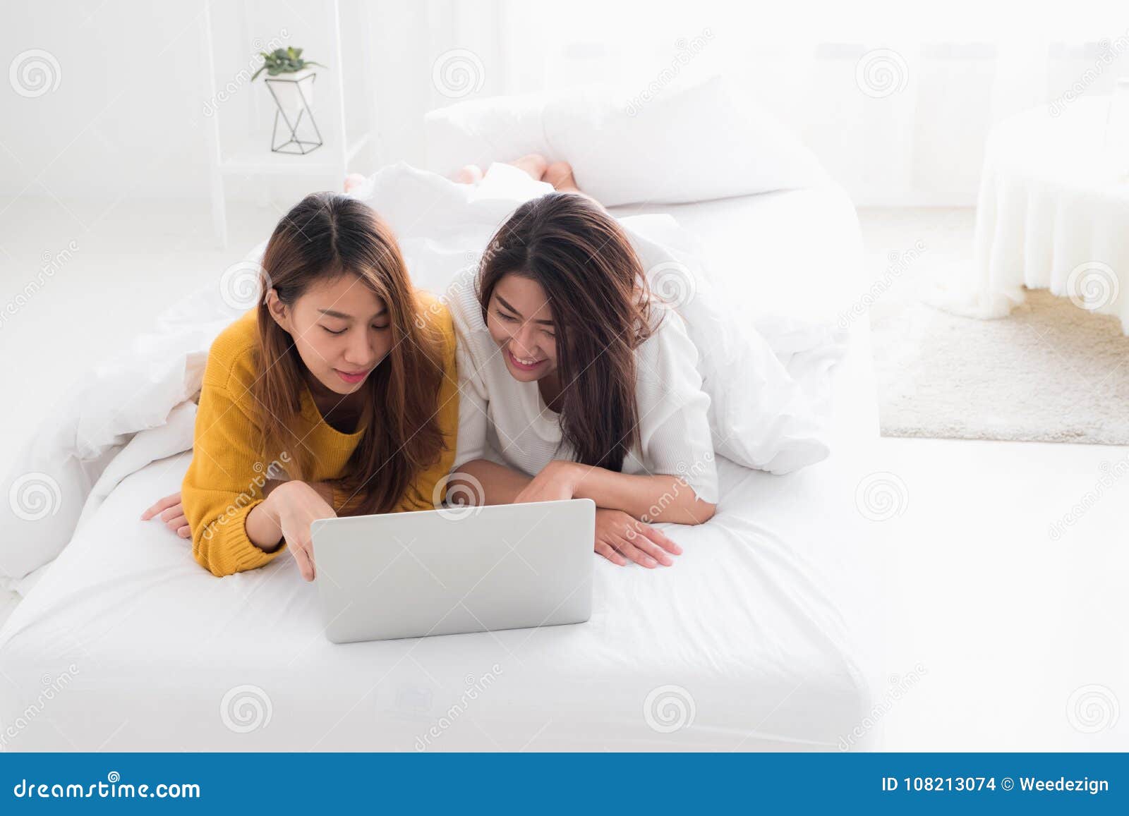 Asia Lesbian Lgbt Couple Lying On Bed Using Laptop Computer Together