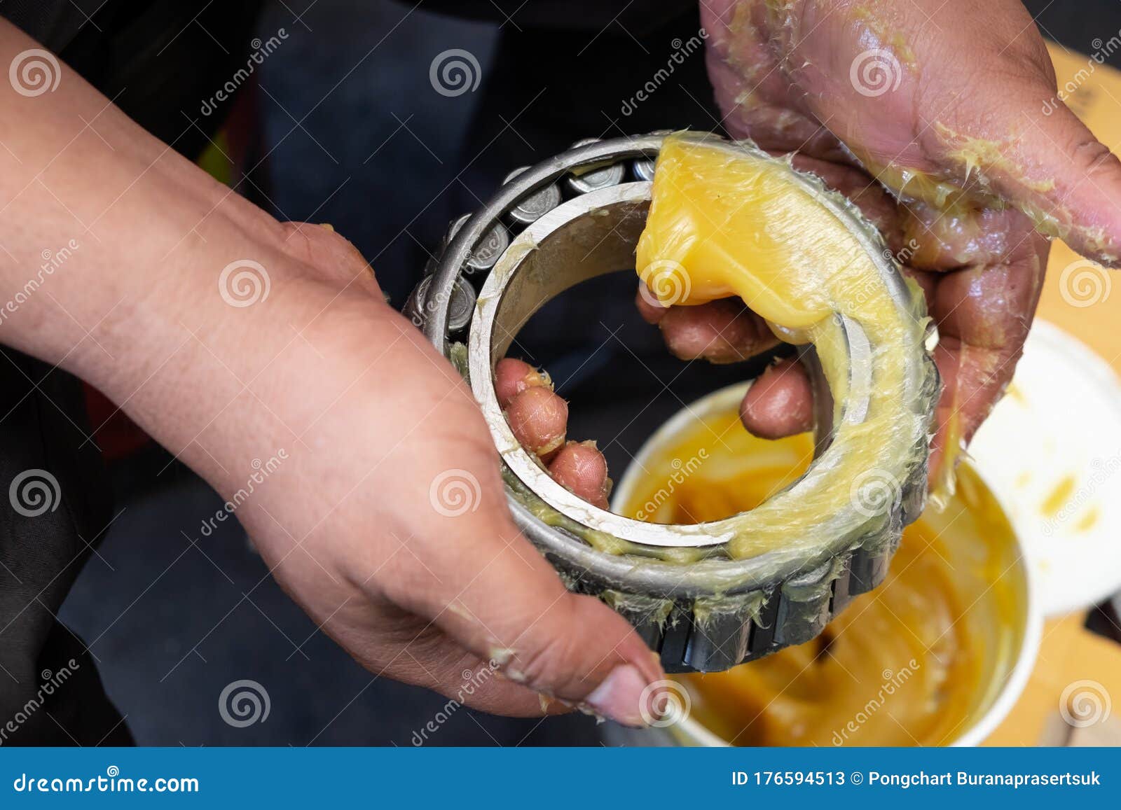 asia man putting lithium grease ep extreme pressure nlgi 3 into wheel bearing for ten wheel track by hand