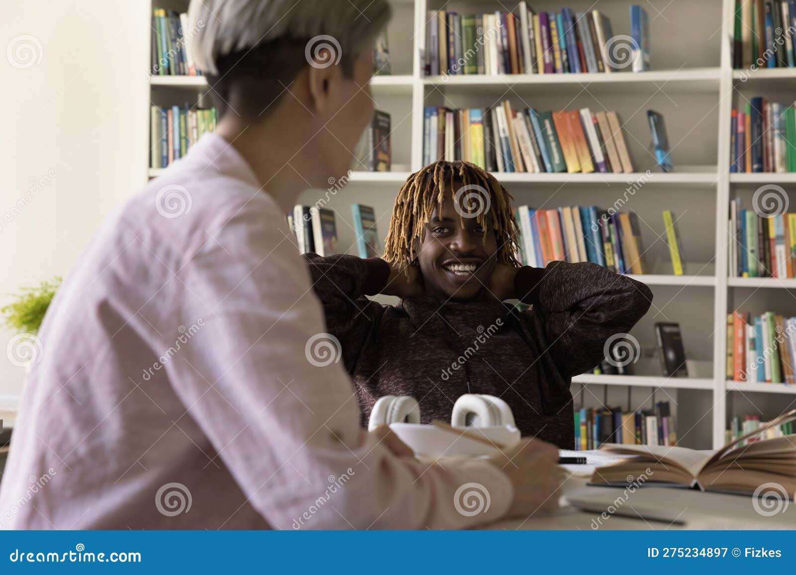 asian and african groupmates blab during break in college library