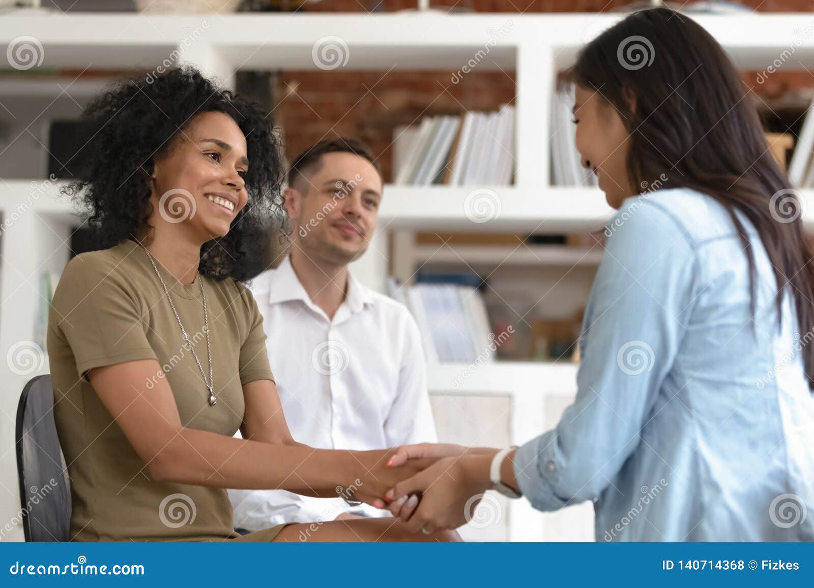 asian and african women holding hands during group therapy session