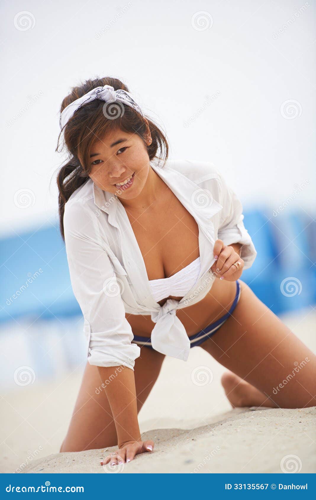 Pretty teenage girl wearing blue bikini in front of white