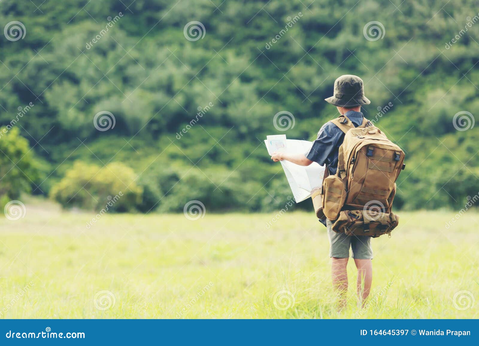 asian boy backpack checking map in jungle forest, trips adventure and tourism for destination and leisure for education and relax