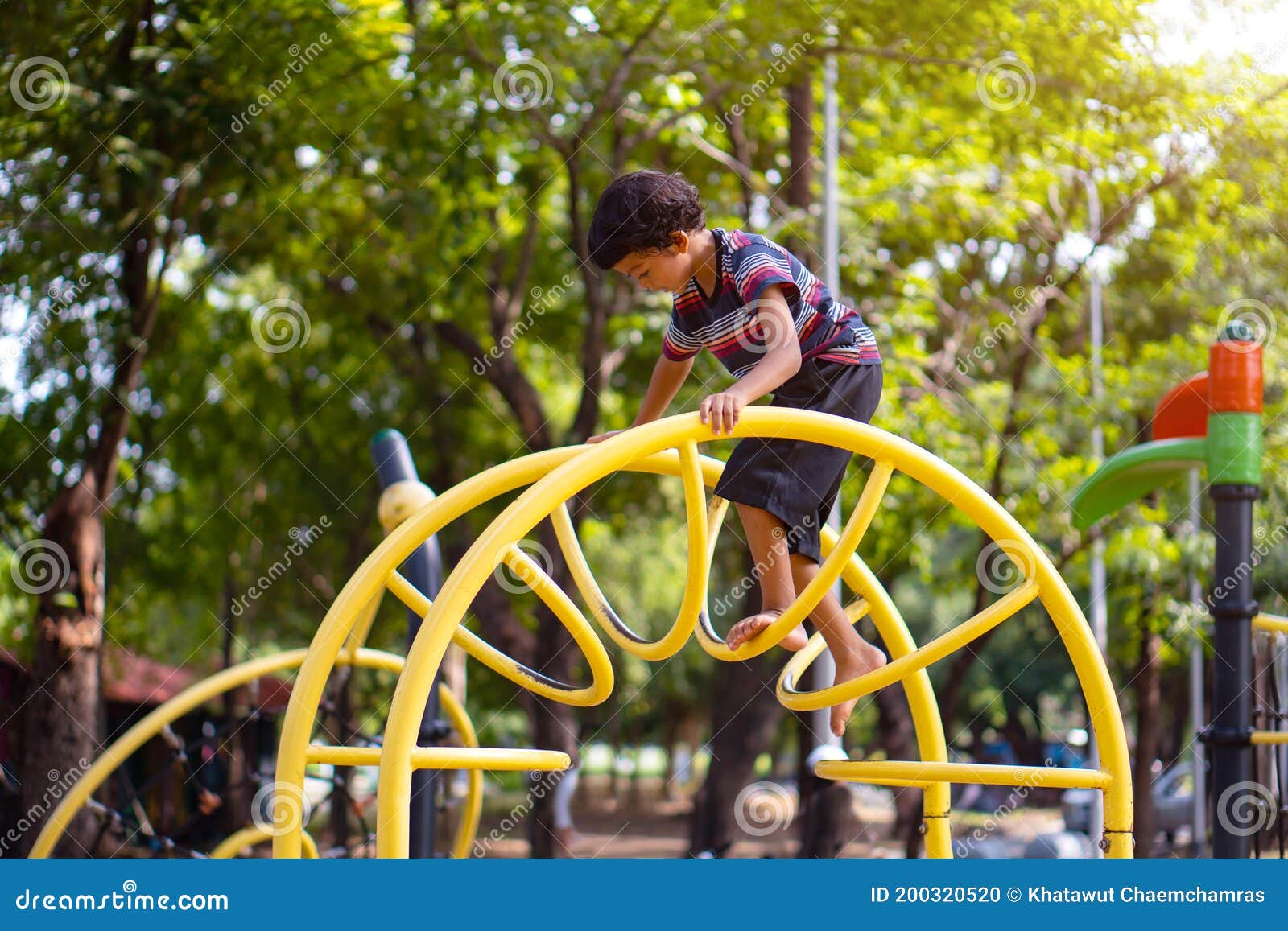 Asian Boy is Climbing on a Playground Equipment in a School Stock Photo