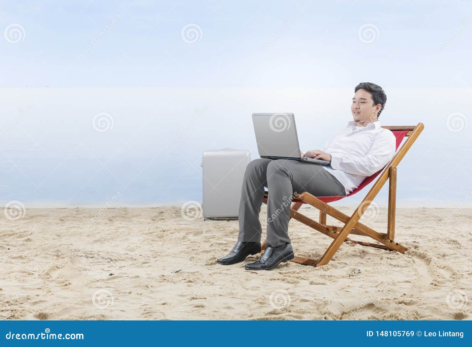 Asian Businessman Working with Laptop Sitting in the Beach Chair on ...