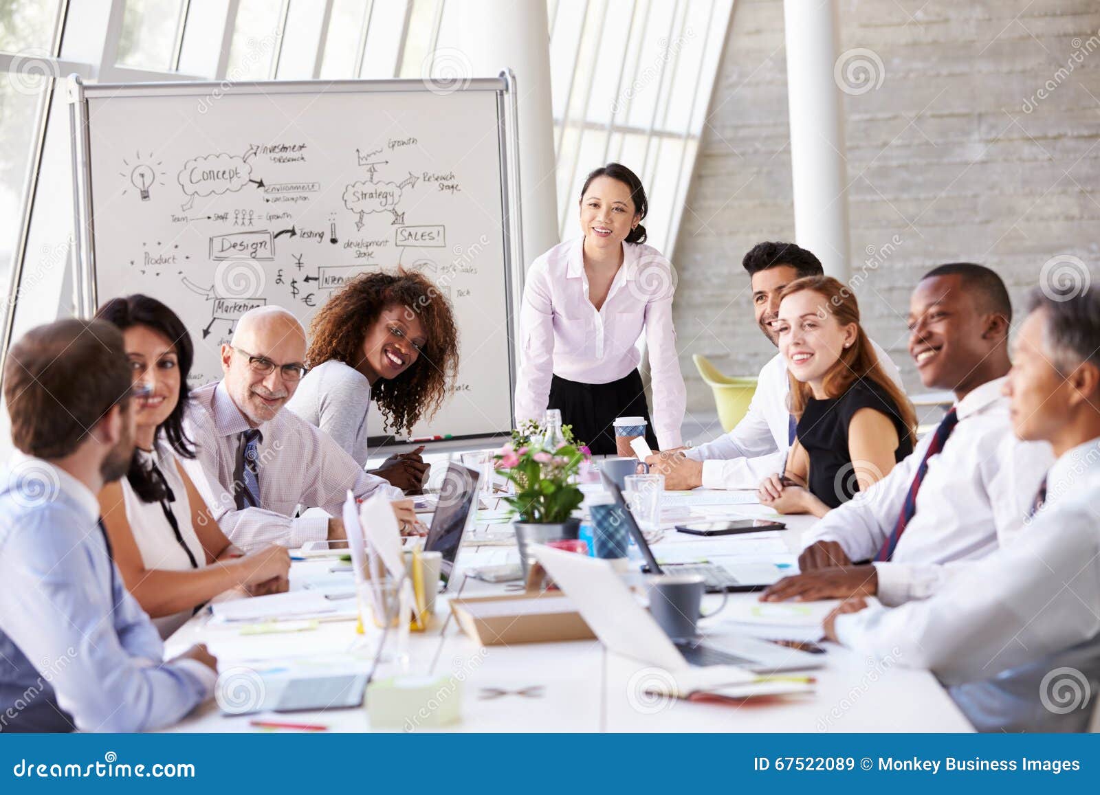 asian businesswoman leading meeting at boardroom table