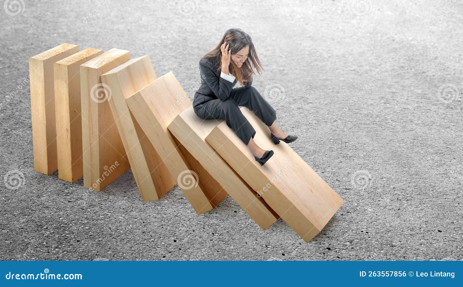 asian businesswoman sitting on topple wooden block