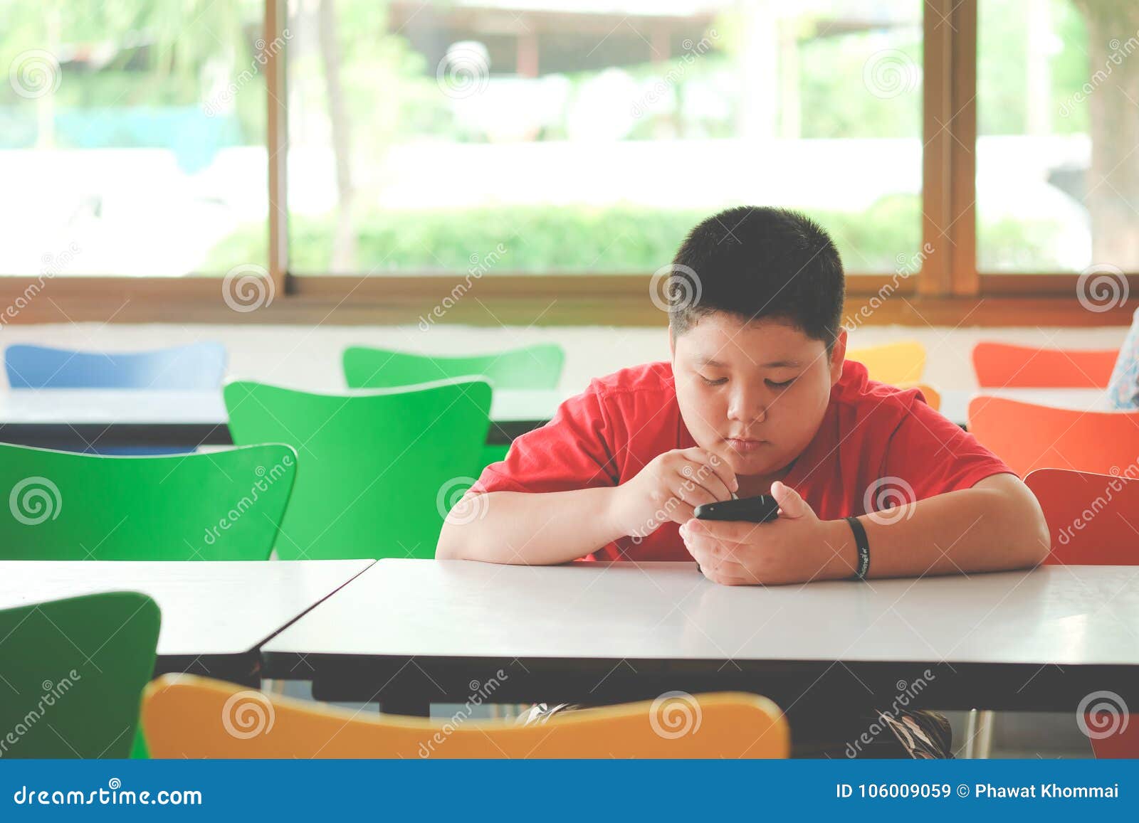 asian child boy are addictive playing tablet and mobile phones