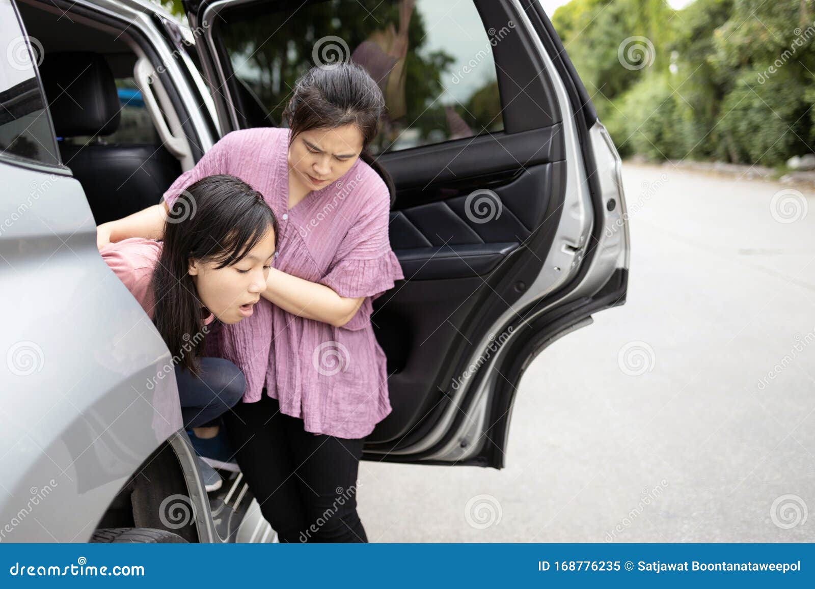 asian child girl about to throw up from car sick or indigestion,female teenage vomiting in a car suffers from motion sickness,