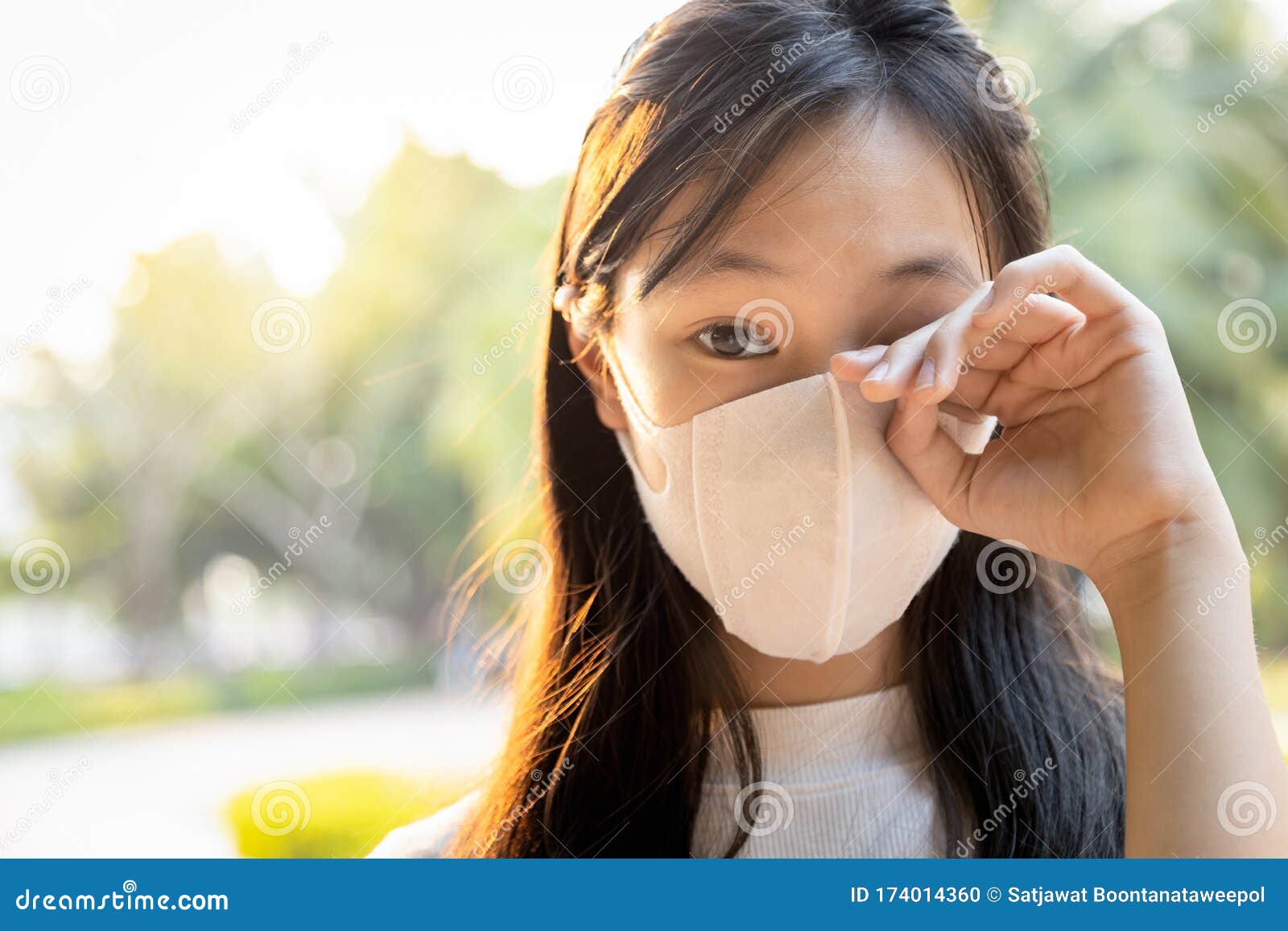 asian child girl wearing protective mask,people rubbing the eyes due to air pollution,fine dust entering the eye,unclean hand,