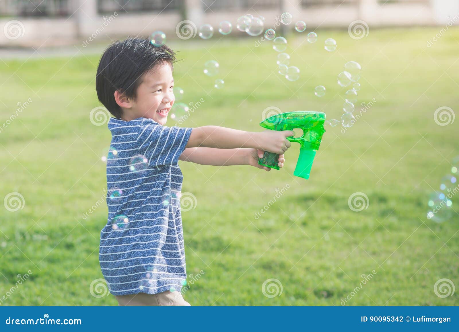 Asian Child Shooting Bubbles from Bubble Gun Stock Photo Image of