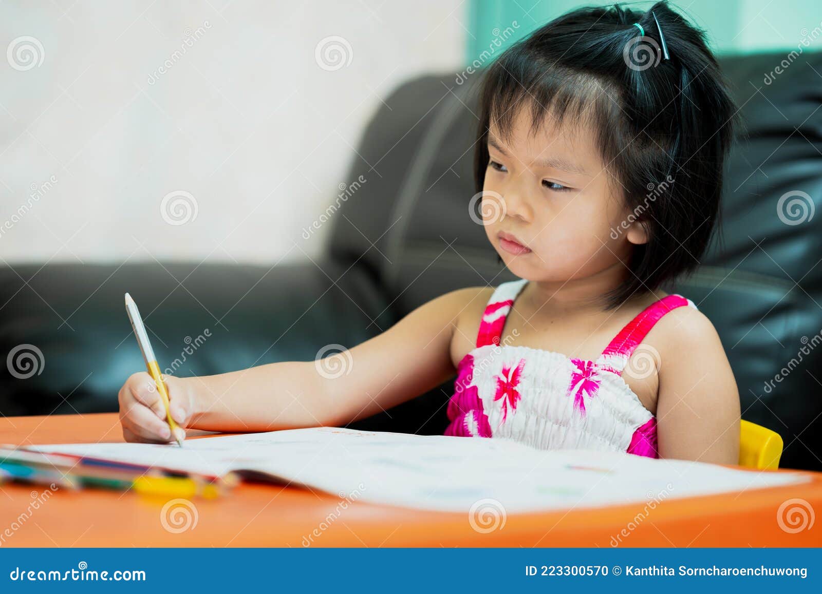 asian child is sluggish having sleepiness while doing homework. girl close half eyes. cute kid aged 4-5 years old