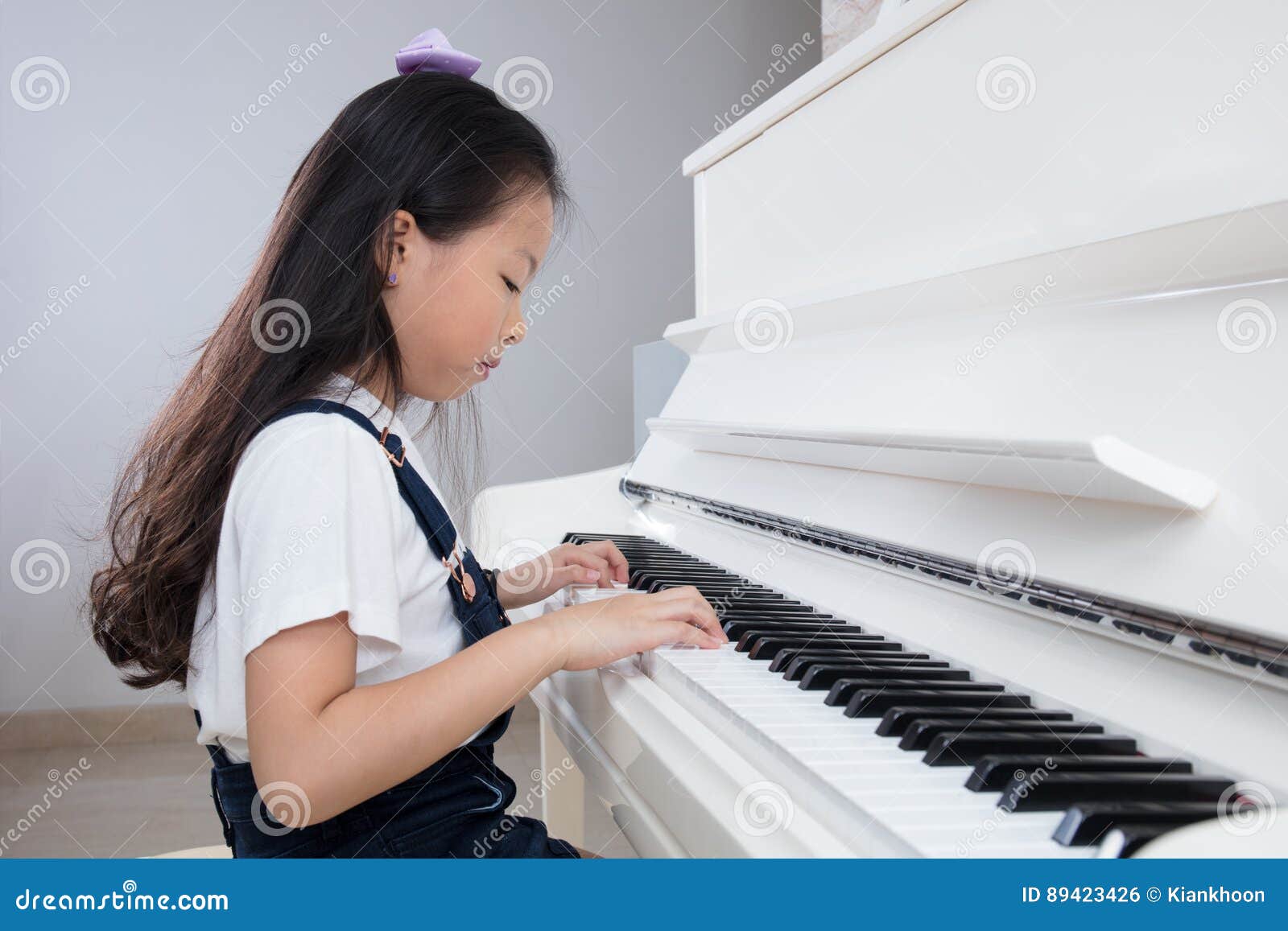 Asian Chinese Little Girl Playing Classical Piano at Home Stock Photo
