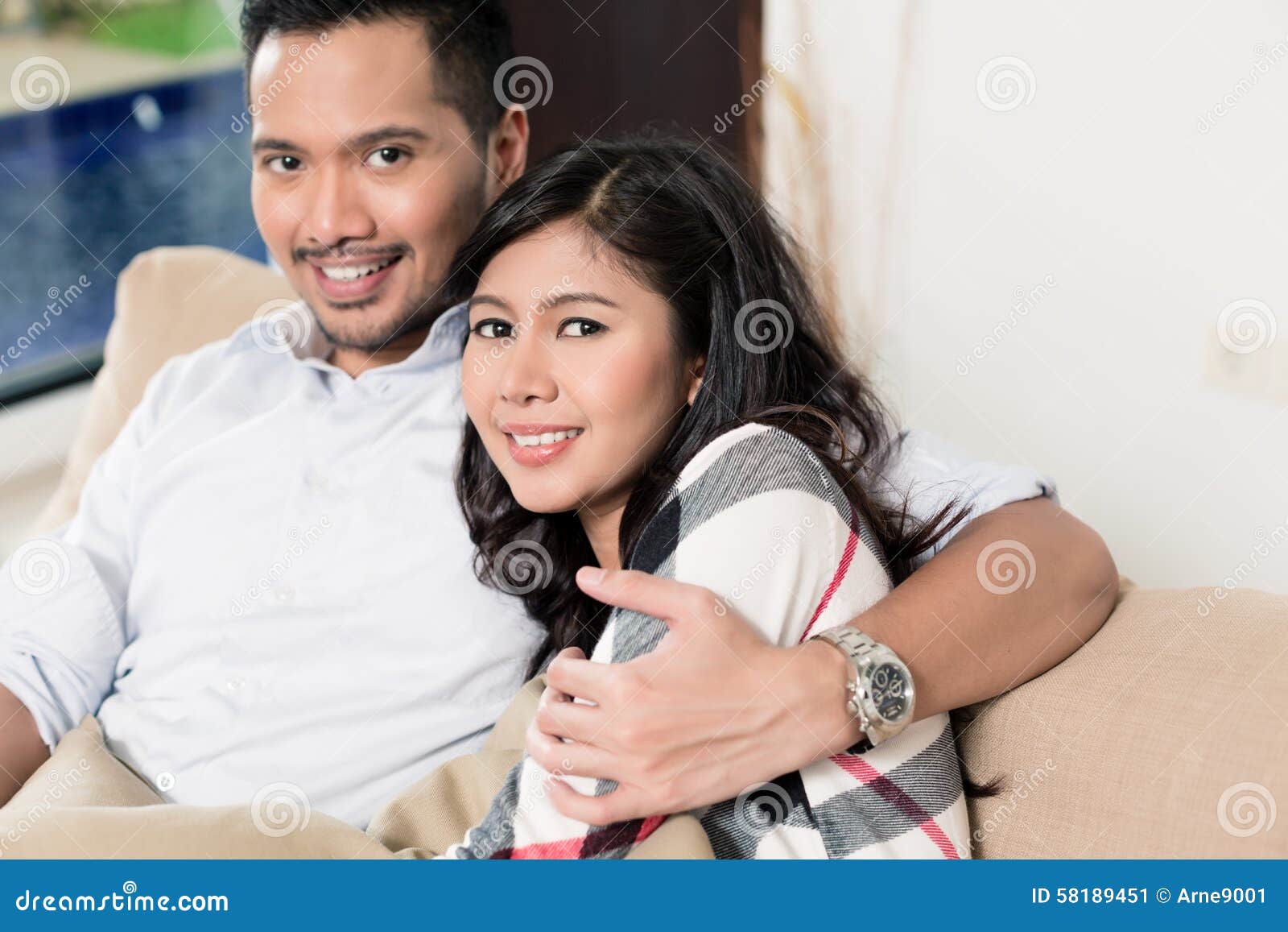 Asian Couple Cuddling On Sofa In Living Room Stock Image I