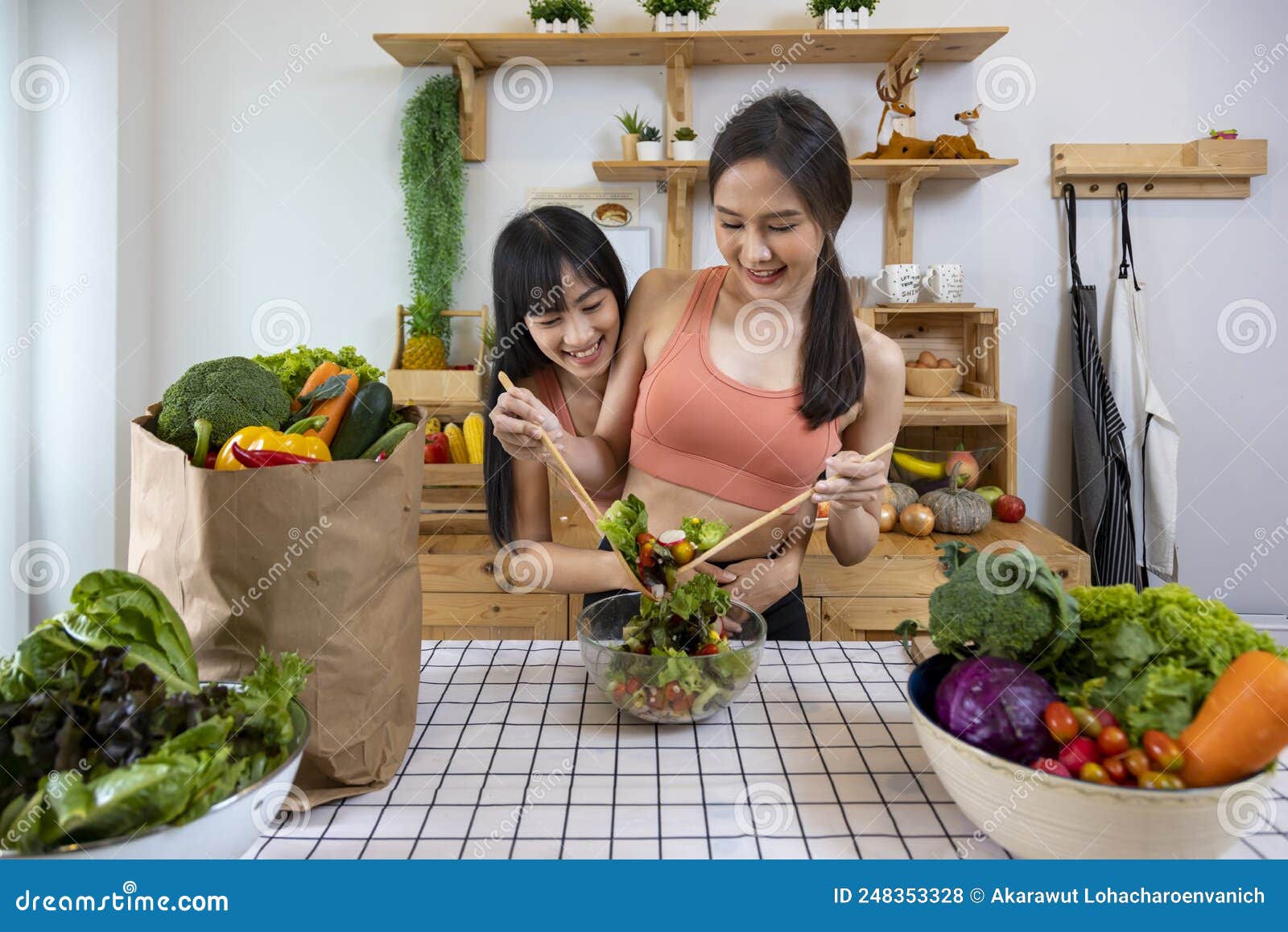 Asian Couple of Same Sex Marriage Cooking Healthy Salad Together in Kitchen during Pride Month To Promote Equality and Differences Stock Photo