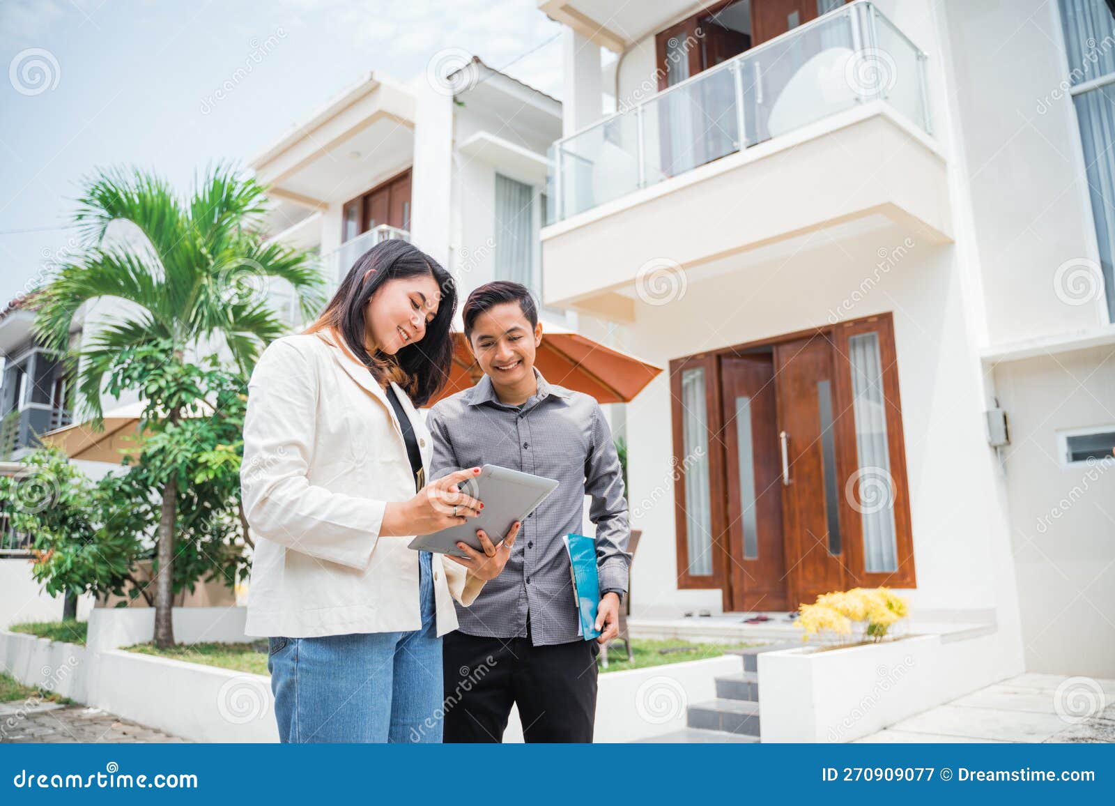 asian couple using pads and clipboards in a residential background